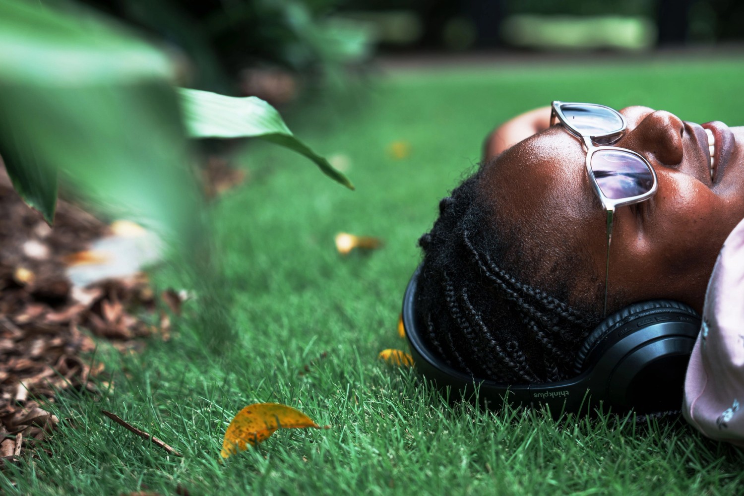 Student laying on grass listening to music