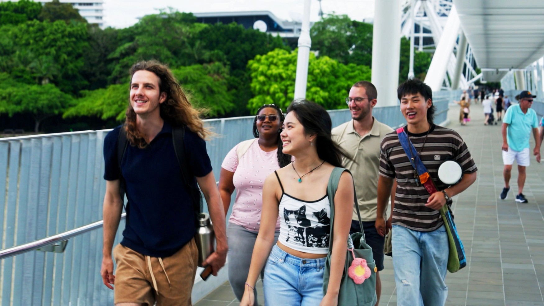 Group of students walking across bridge from South Bank