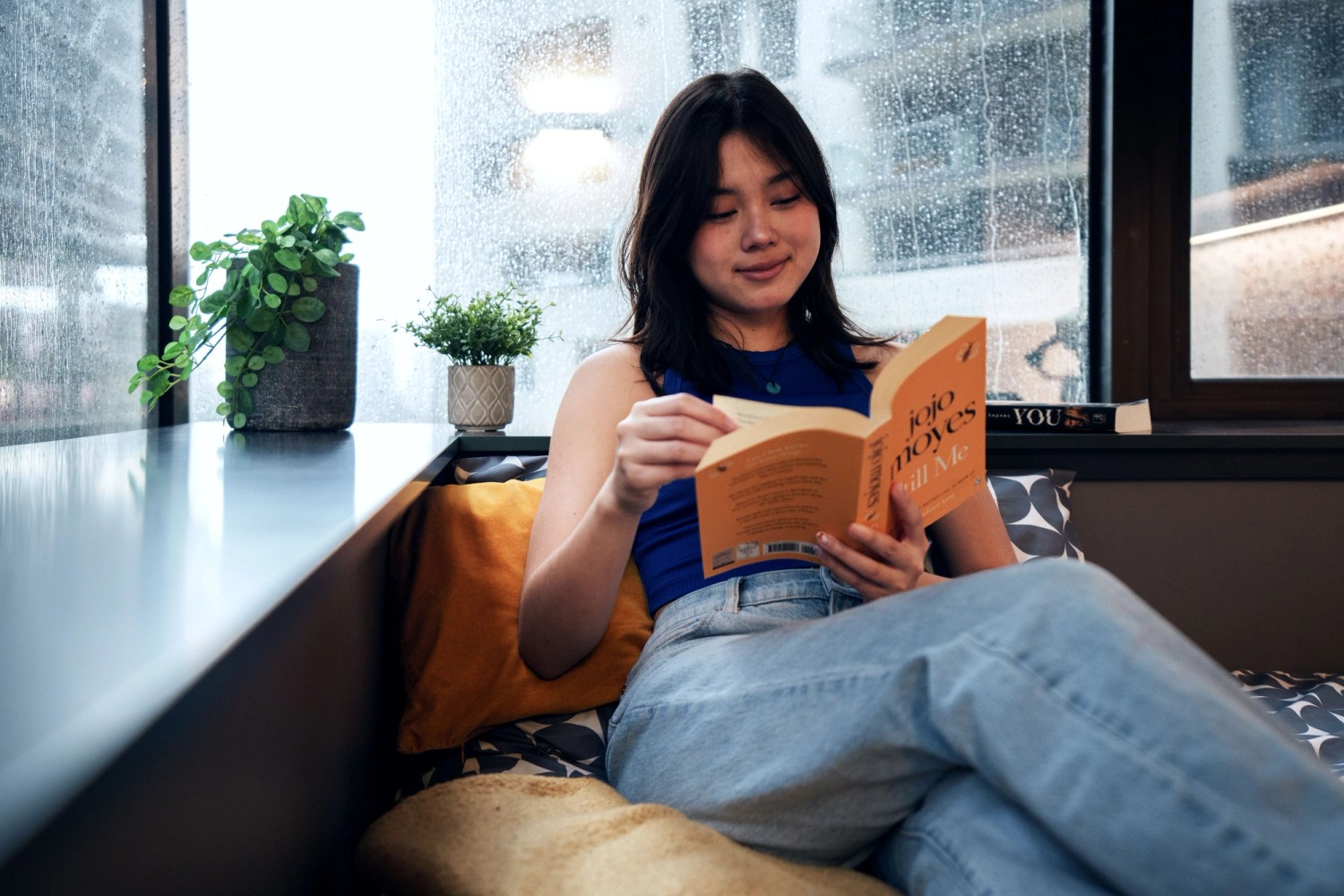Student reading on bed in room
