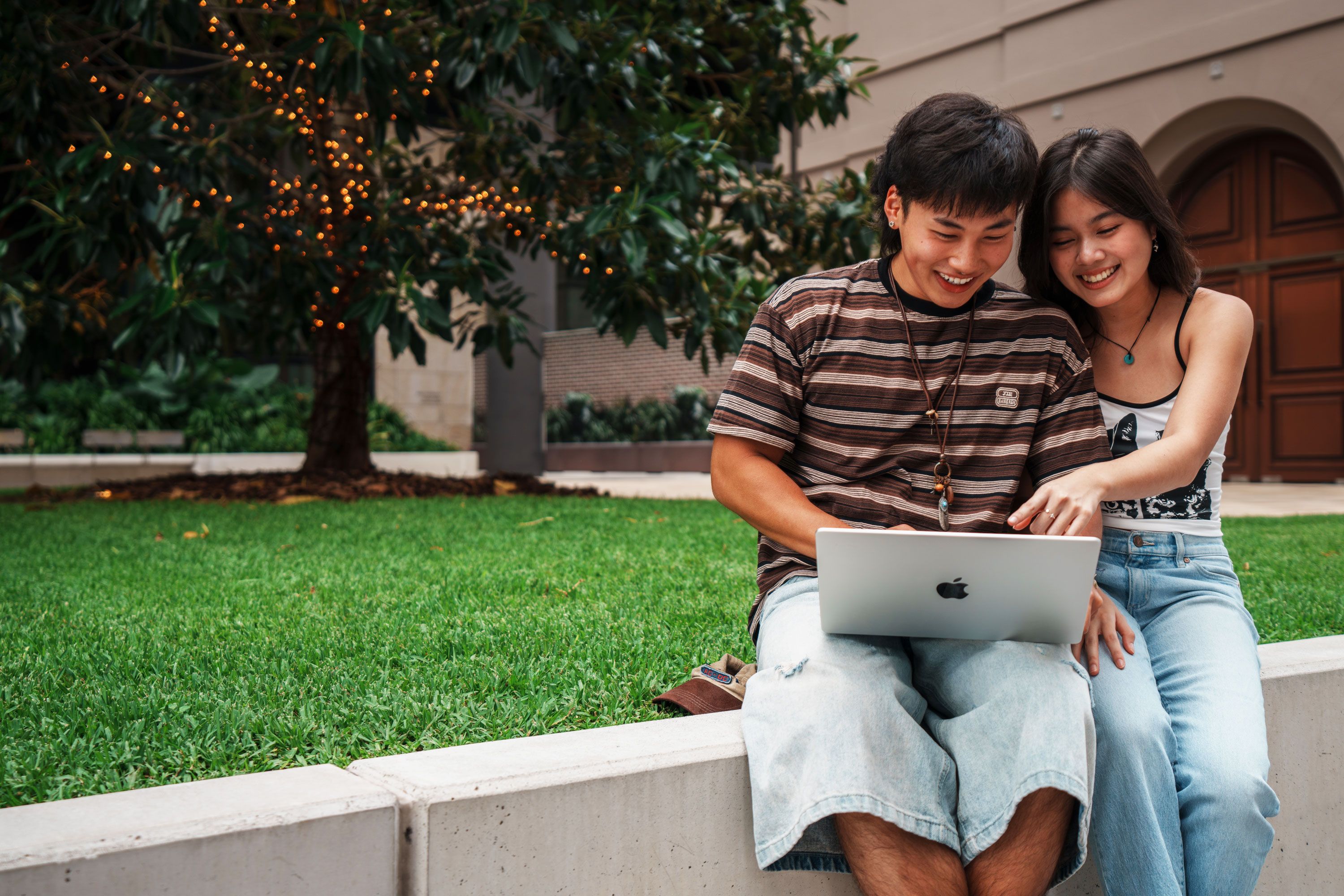 Two students working together on a laptop