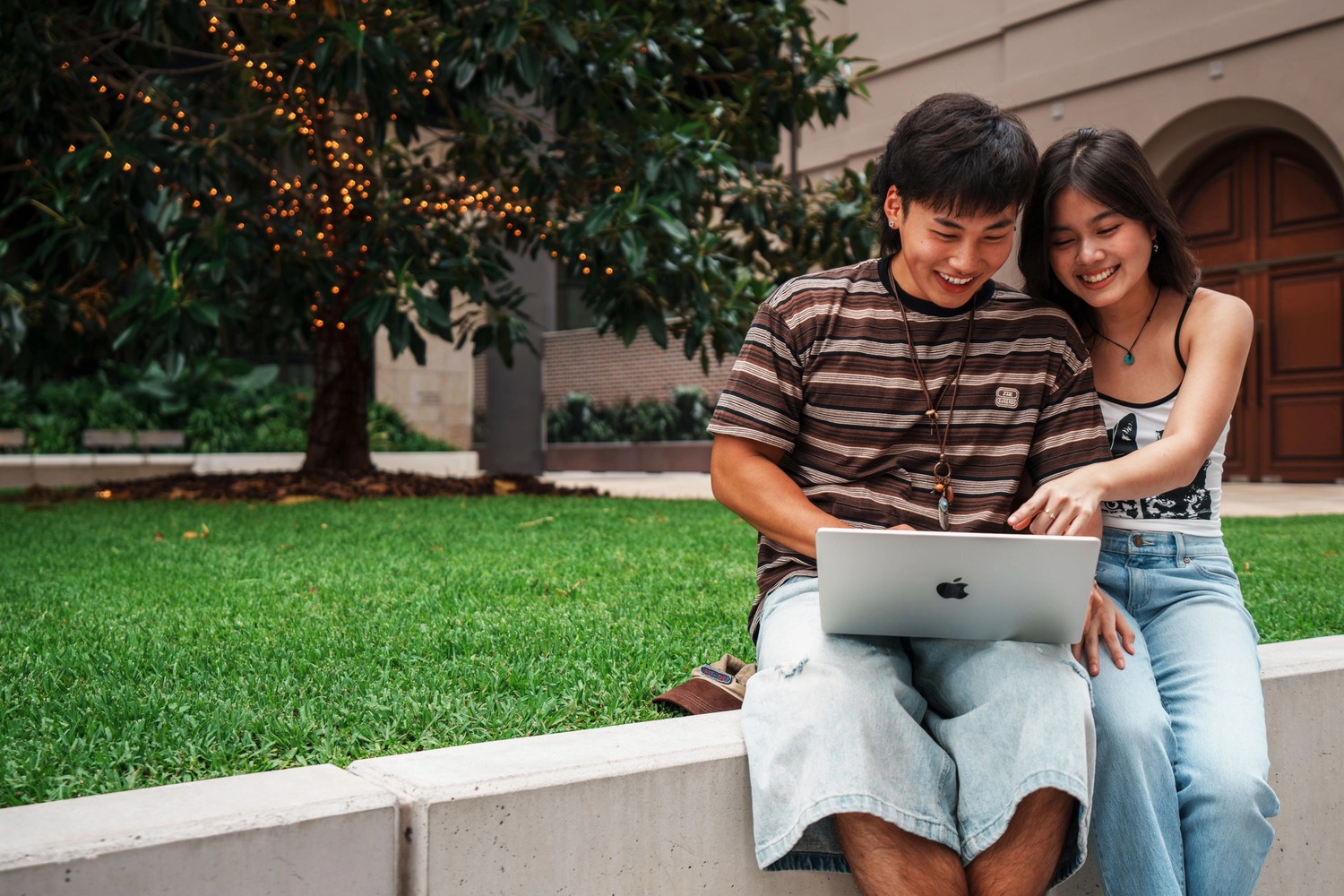 Two students working together on a laptop
