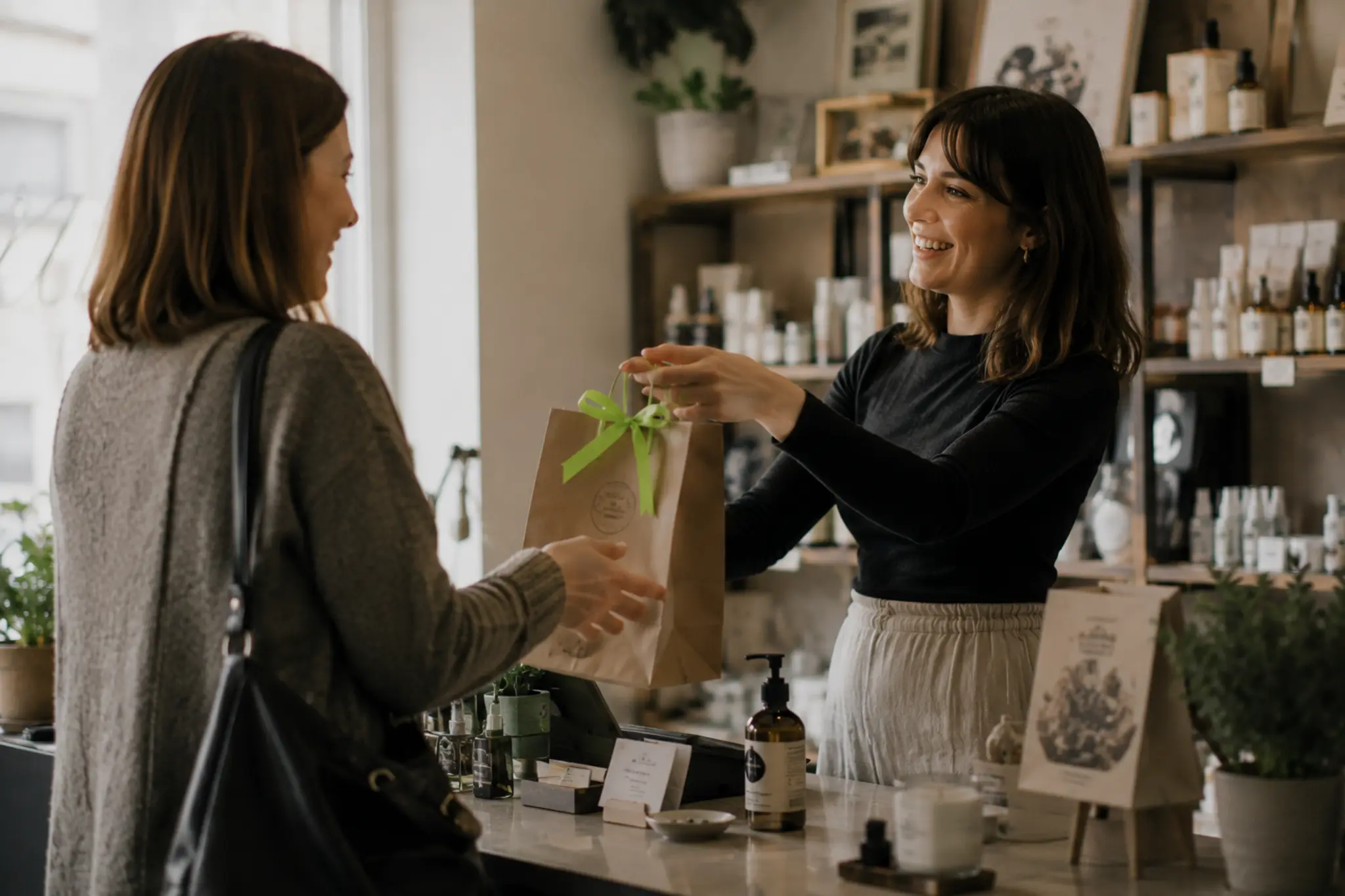 Store owner greeting a repeat customer — the client relationship a business owns through its own website