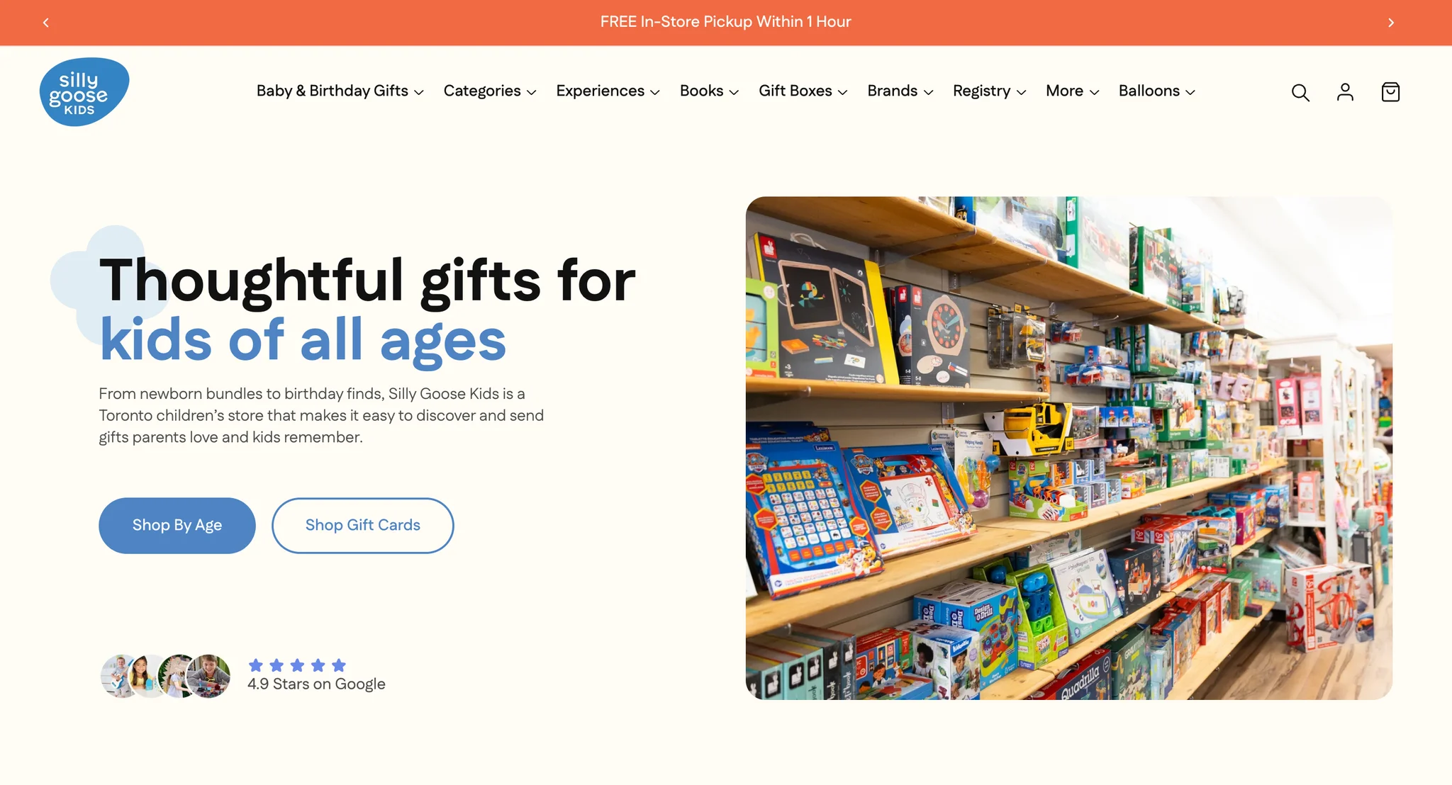 Silly Goose Kids homepage hero on cream: "Thoughtful gifts for kids of all ages" in black and blue over a pale blue cloud, a line about newborn bundles and birthday finds, Shop By Age and Shop Gift Cards buttons and a Google rating line next to four small round photos of children with toys, with a photo of toy-filled shelves in the shop on the right