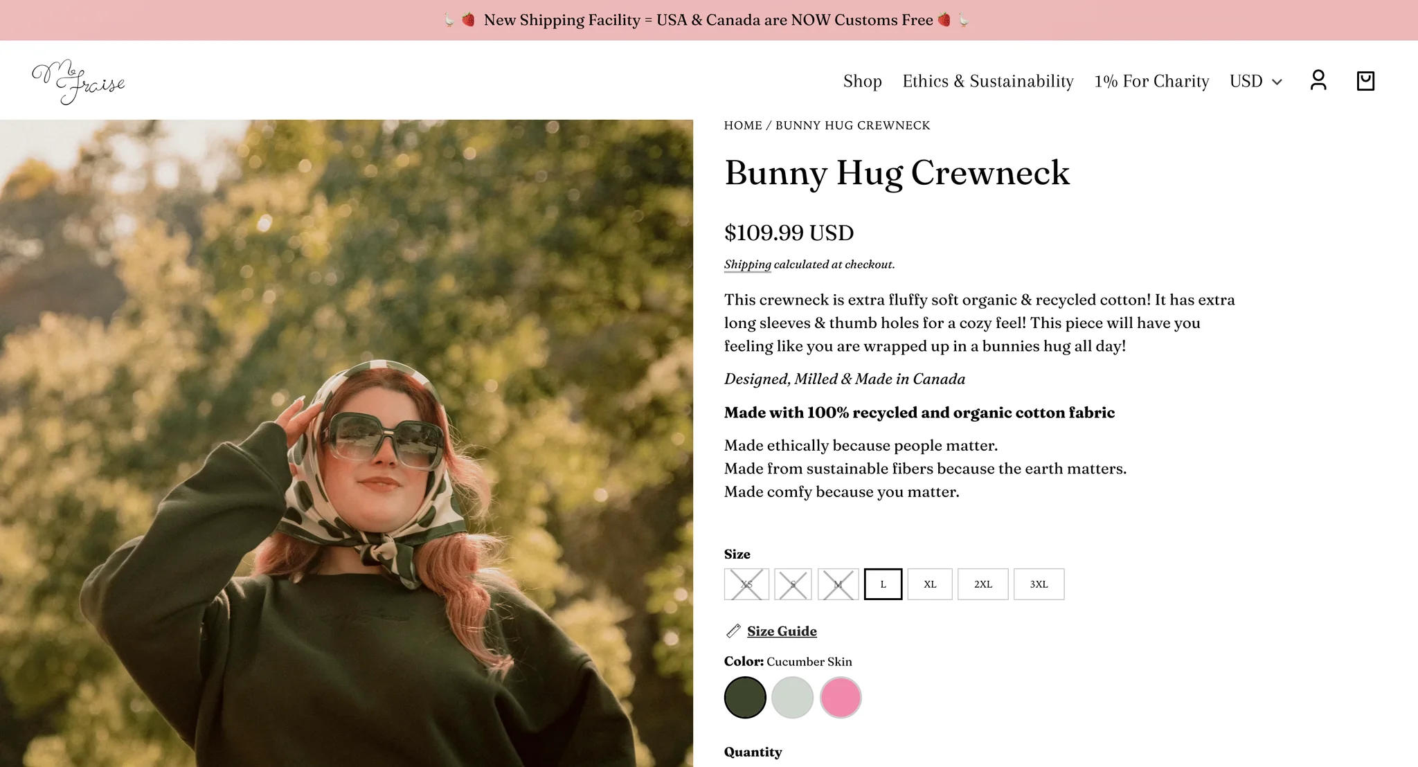 Bunny Hug Crewneck product page with a model in the dark green crewneck, a polka dot headscarf and sunglasses, beside the $109.99 price, a description of the long sleeves and thumbholes, and a size row with the smaller sizes crossed out as sold out