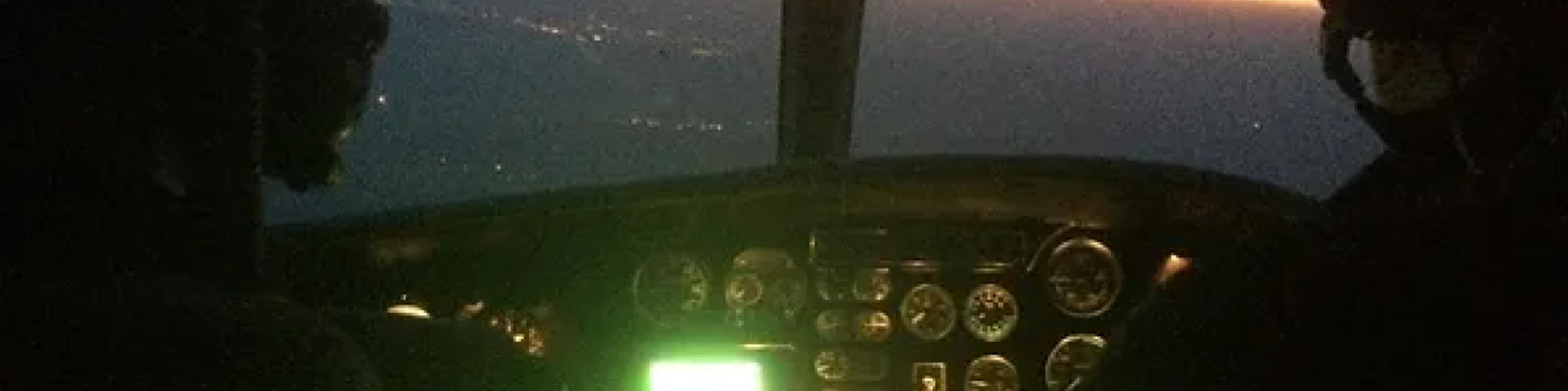 Helicopter cockpit instruments glowing during a night flight