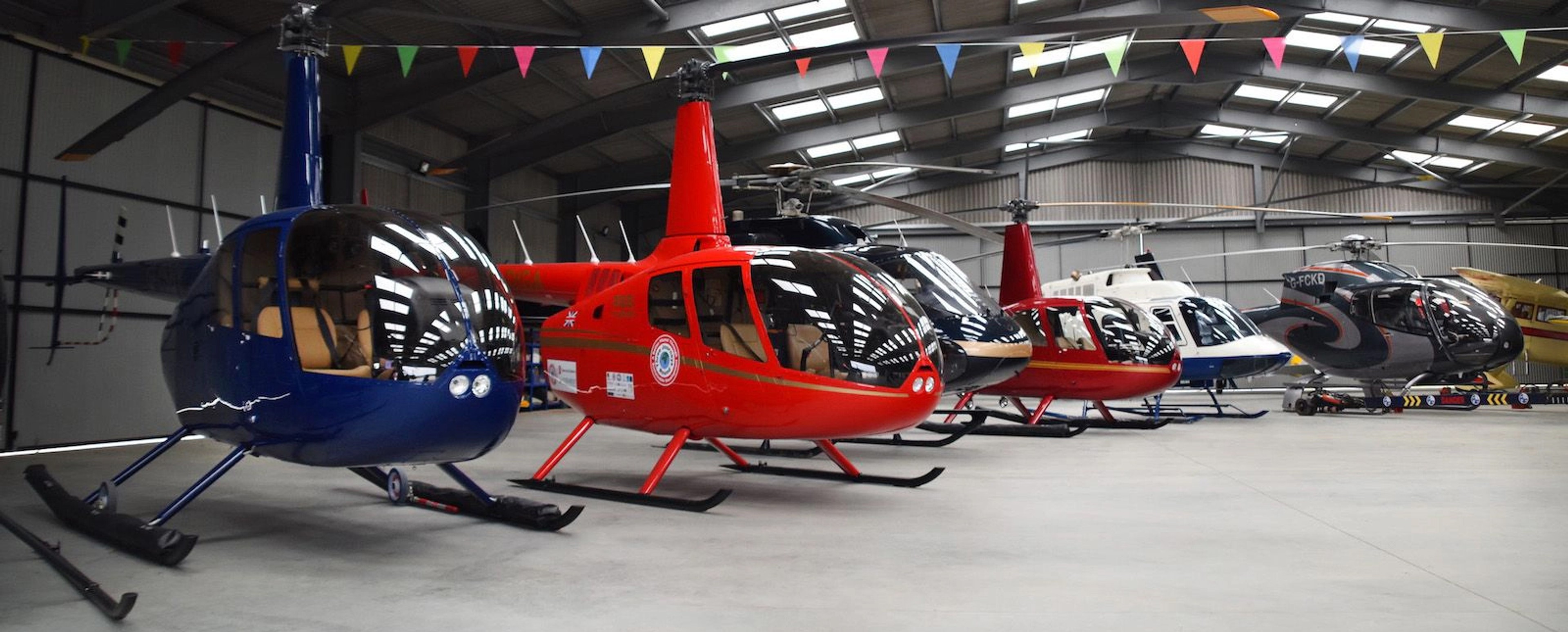 Robinson helicopters lined up inside the hangar at White Waltham