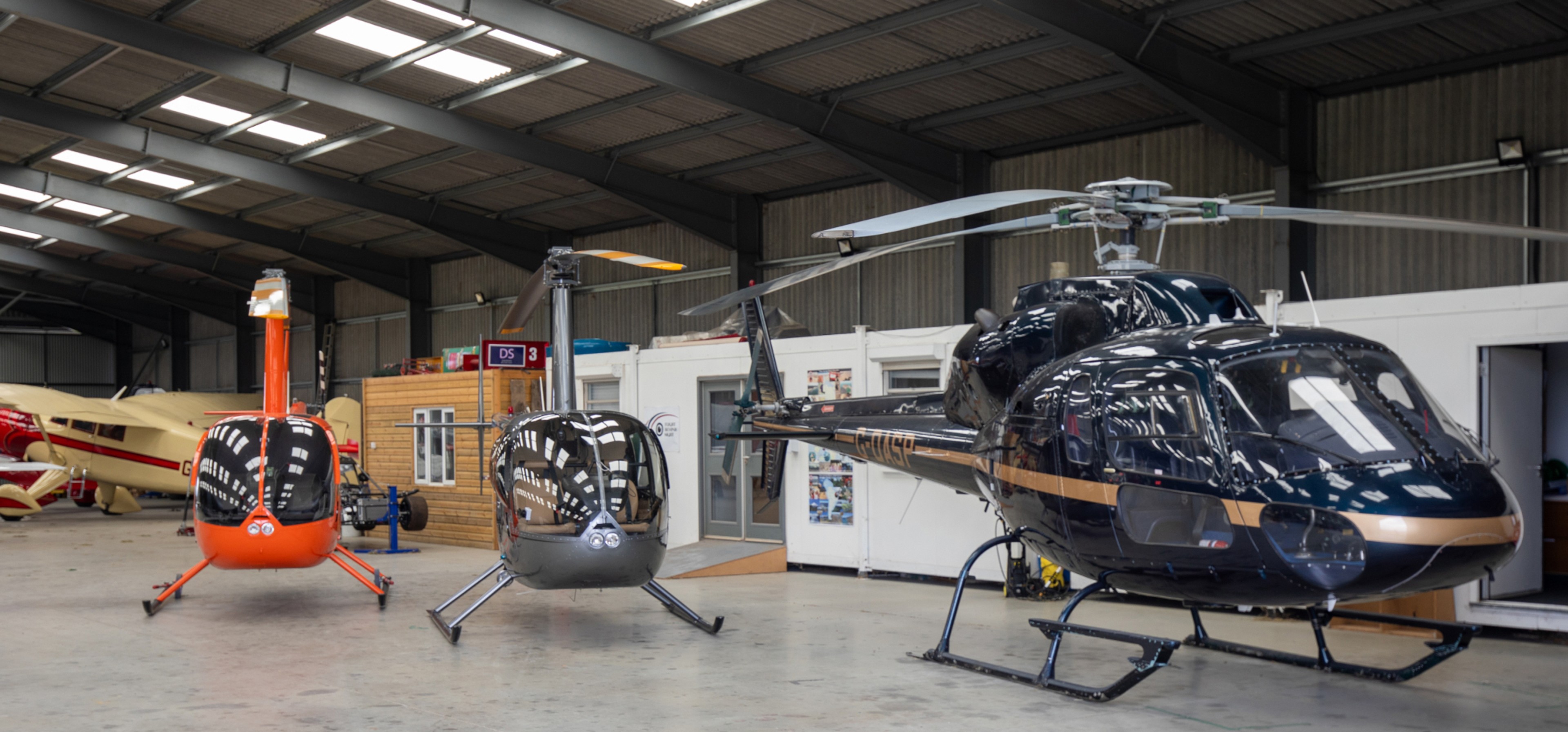 Helicopters parked inside the Helicopter Services hangar at White Waltham
