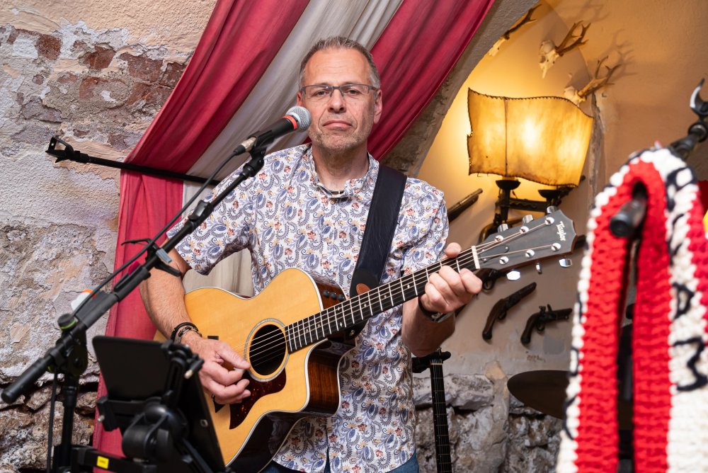 Ein Musiker der Original Austrobuam spielt Akustikgitarre im Mary's.