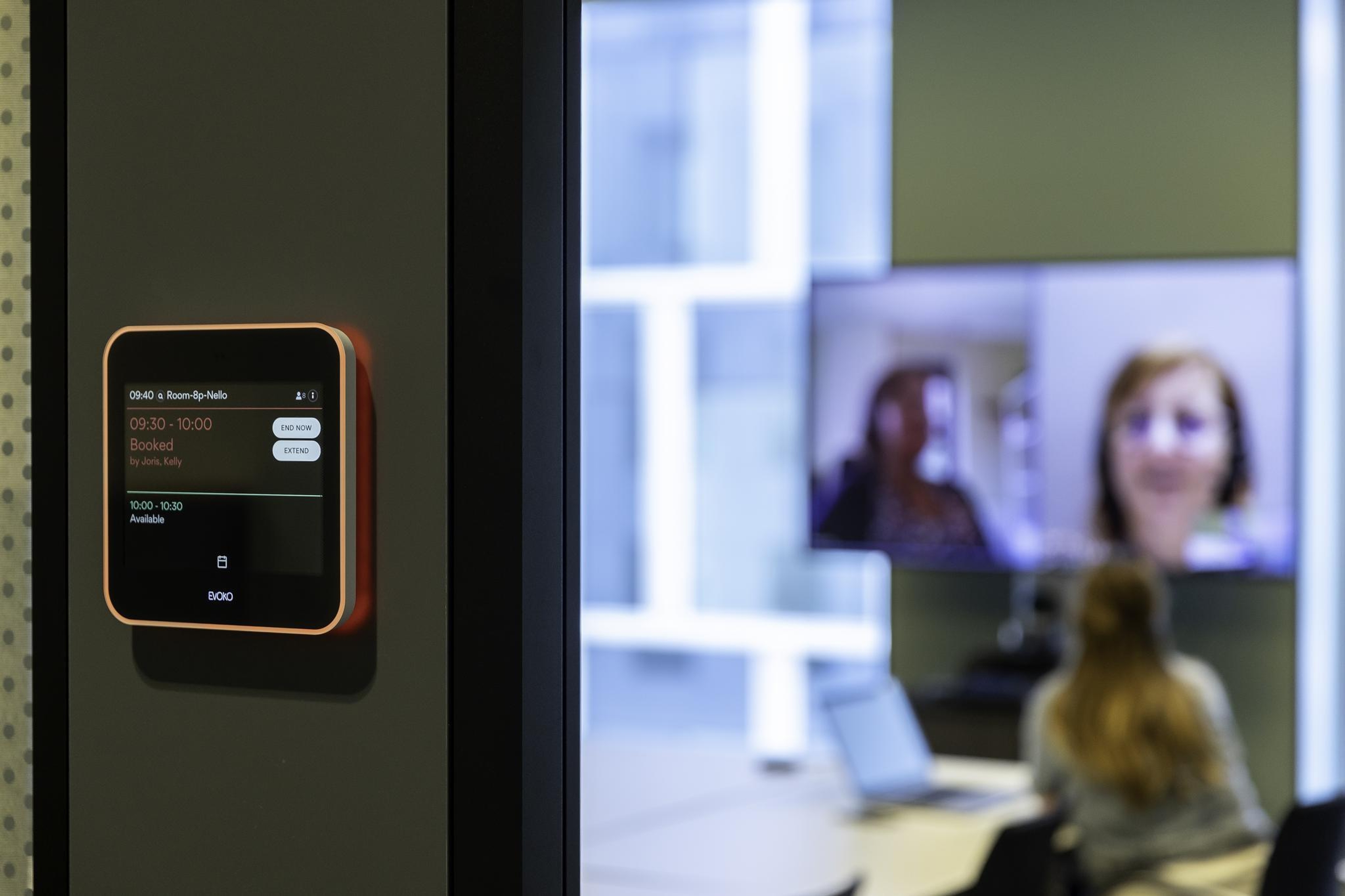 Femme assise dehors sur un muret en train de téléphoner avec son PC à côté d'elle