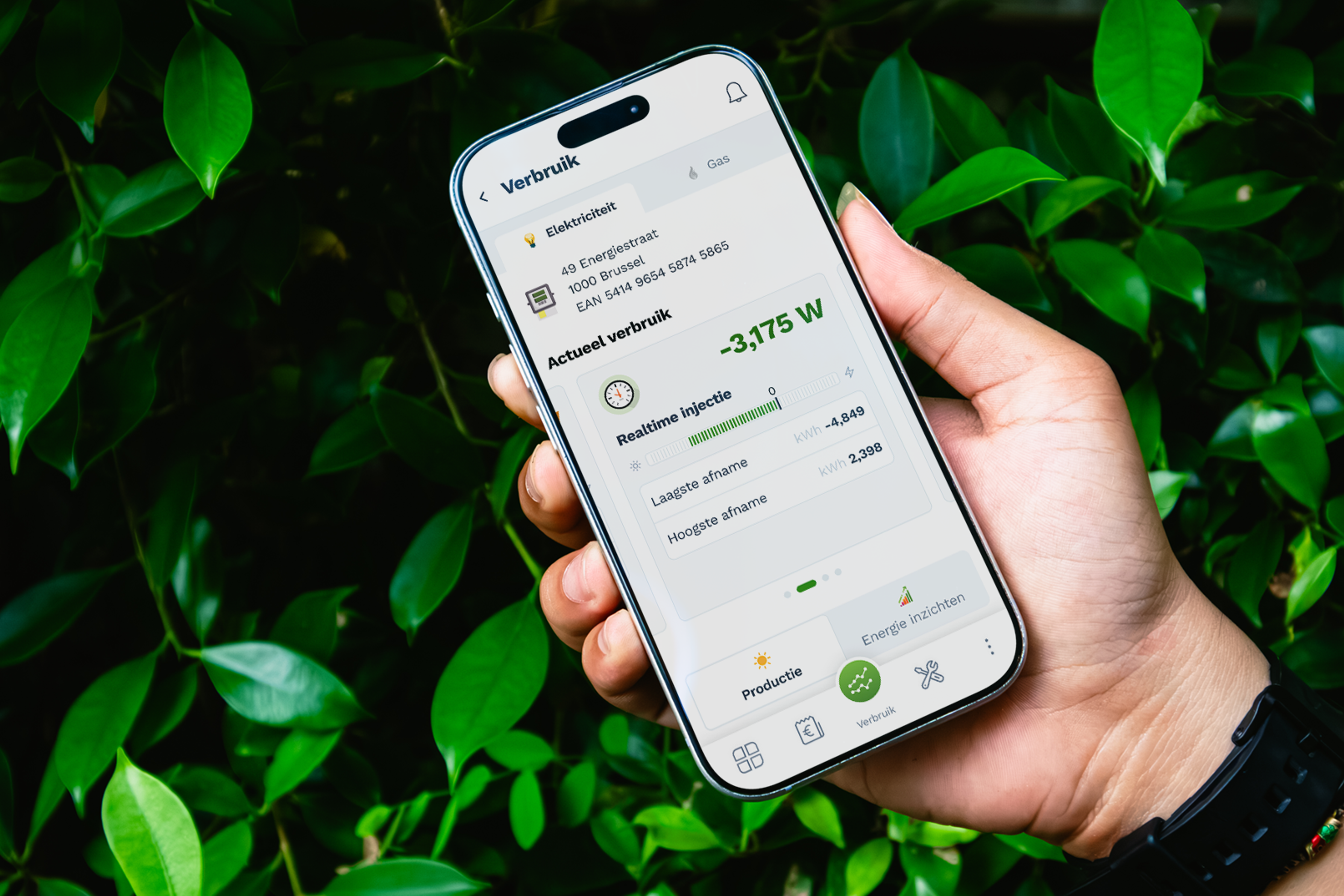 Op achtergond van groene balderen houdt een hand een smartphone vast met daarin een scherm van EnergyControl Monitor.