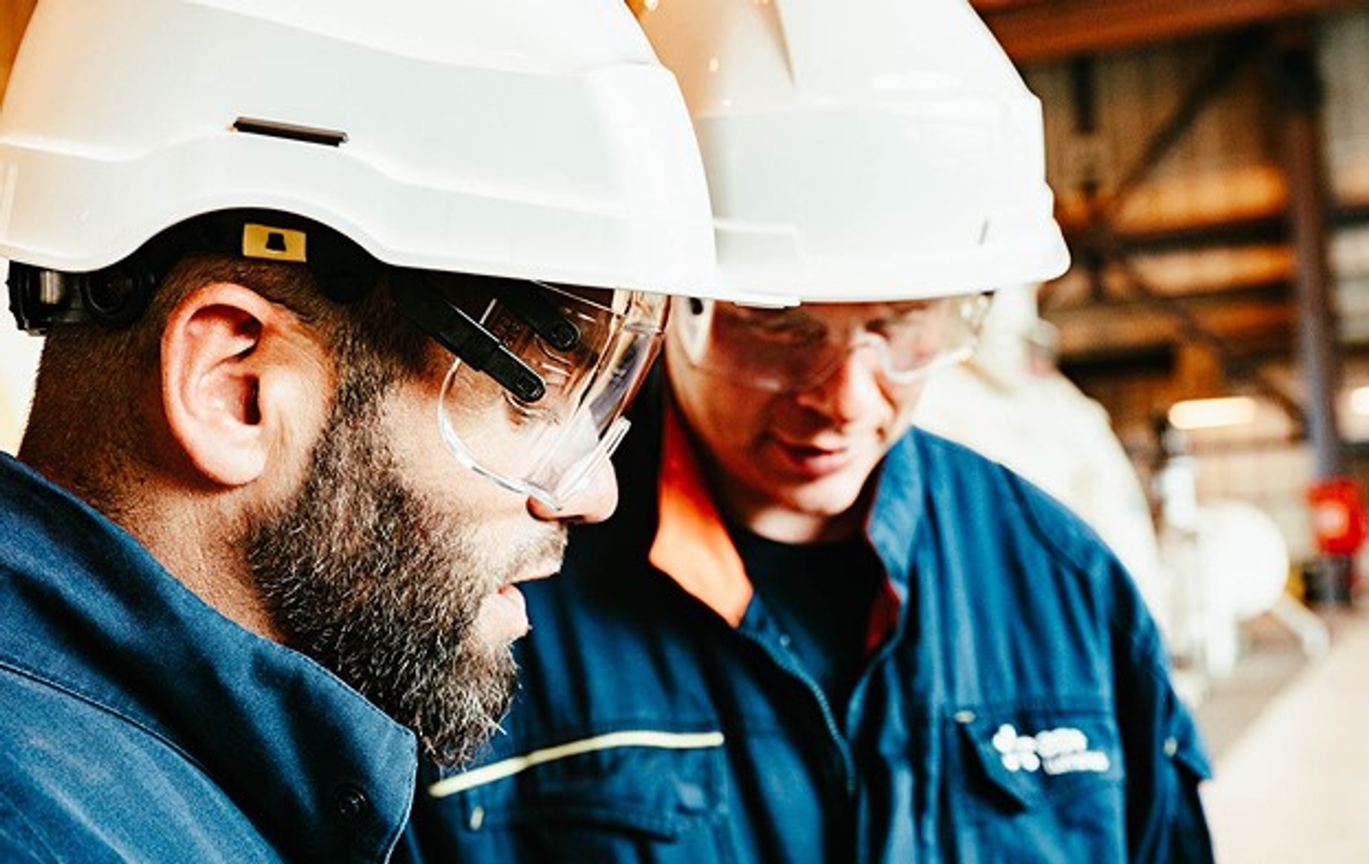 2 techniciens Luminus avec casque de sécurité en discussion