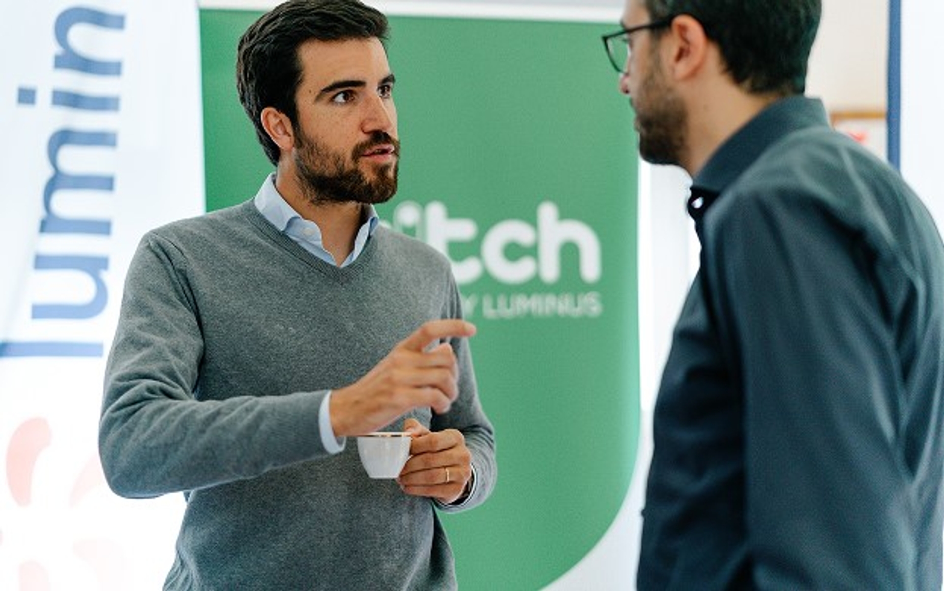 Deux collègues discutant devant un panneau Luminus Switch