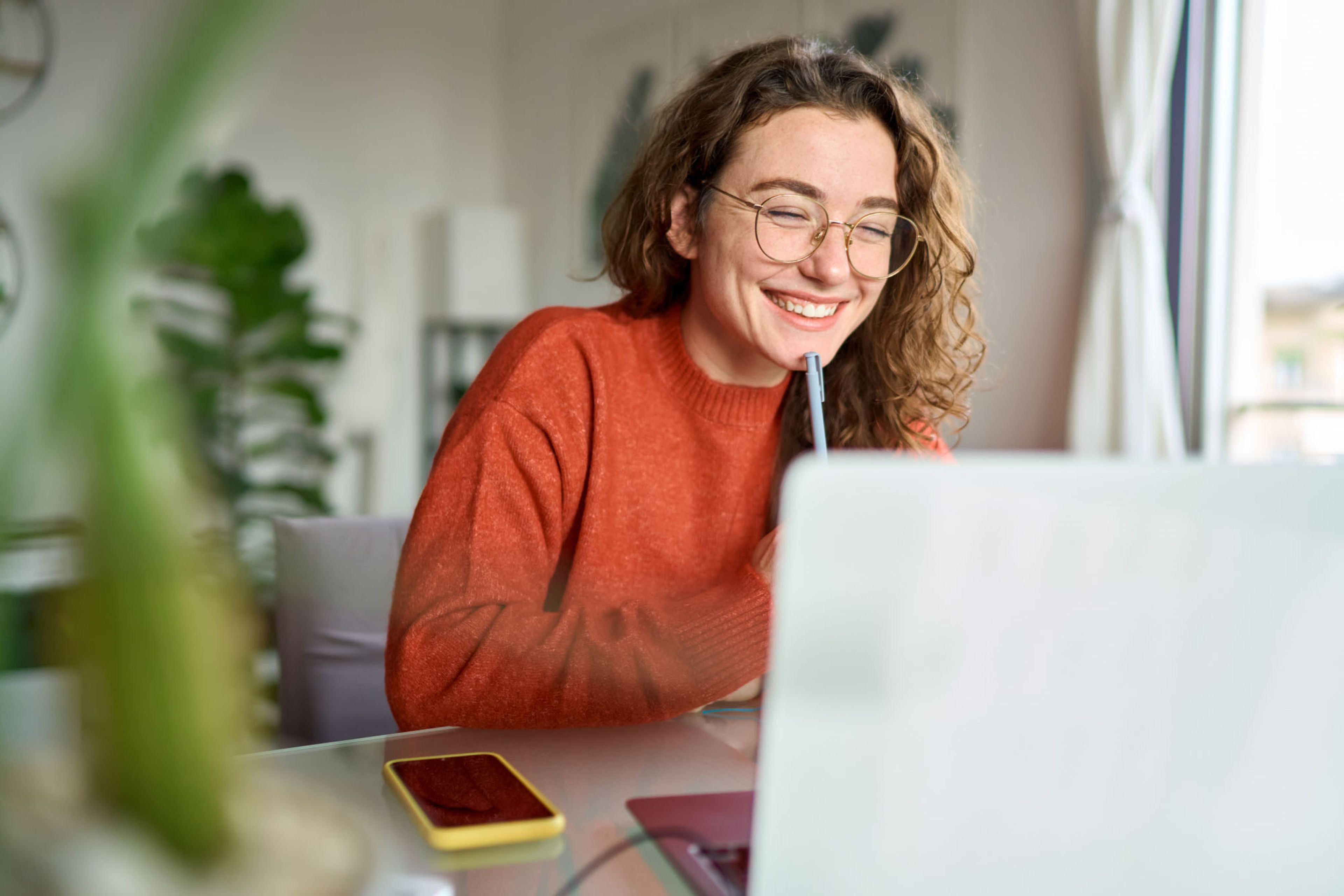 Stages bij Luminus - jonge vrouw kijkt lachend naar het scherm van haar laptop.