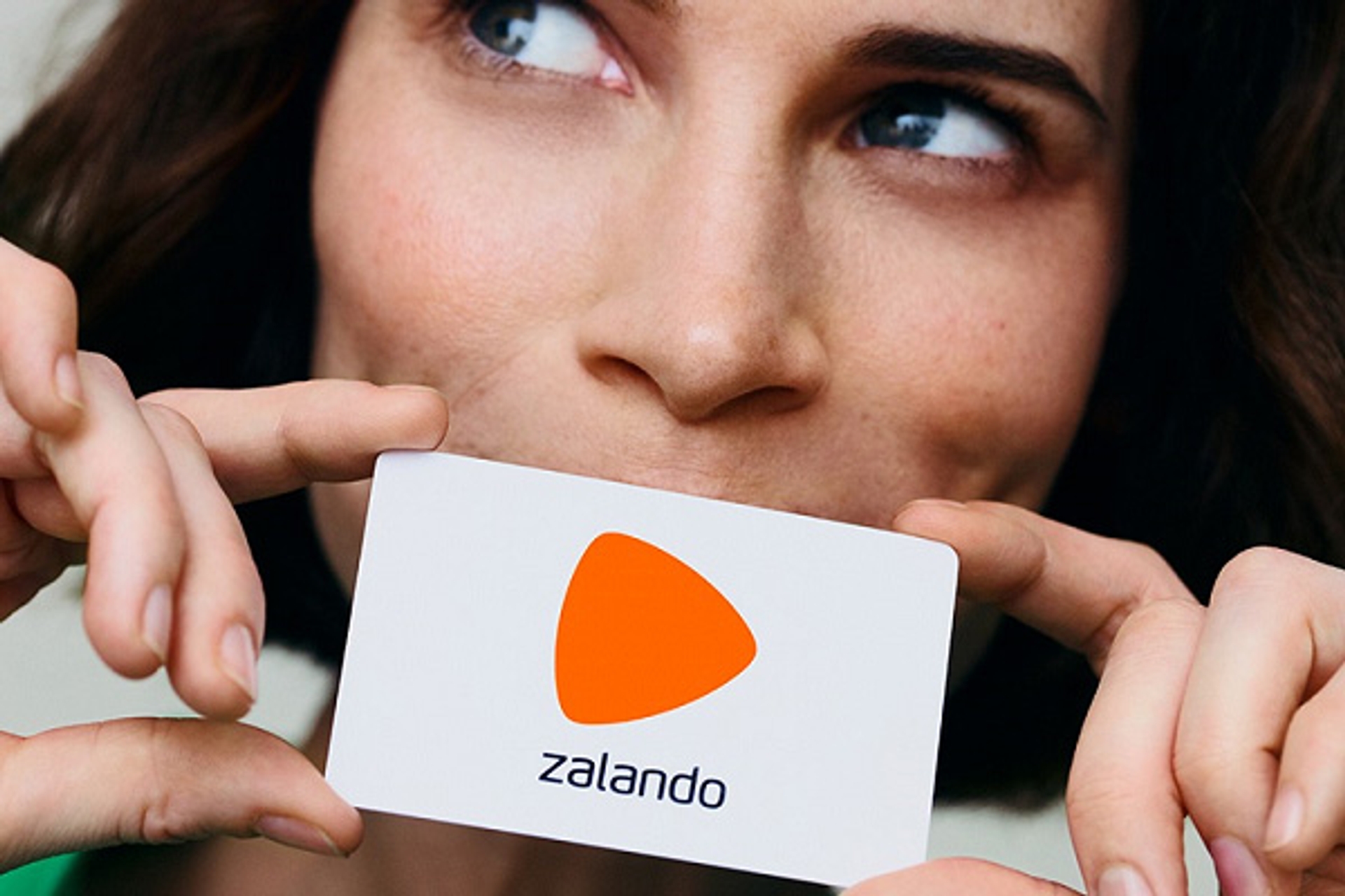 5% korting op je voucher bij Zalando, dame houdt kaartje Zalando voor de mond