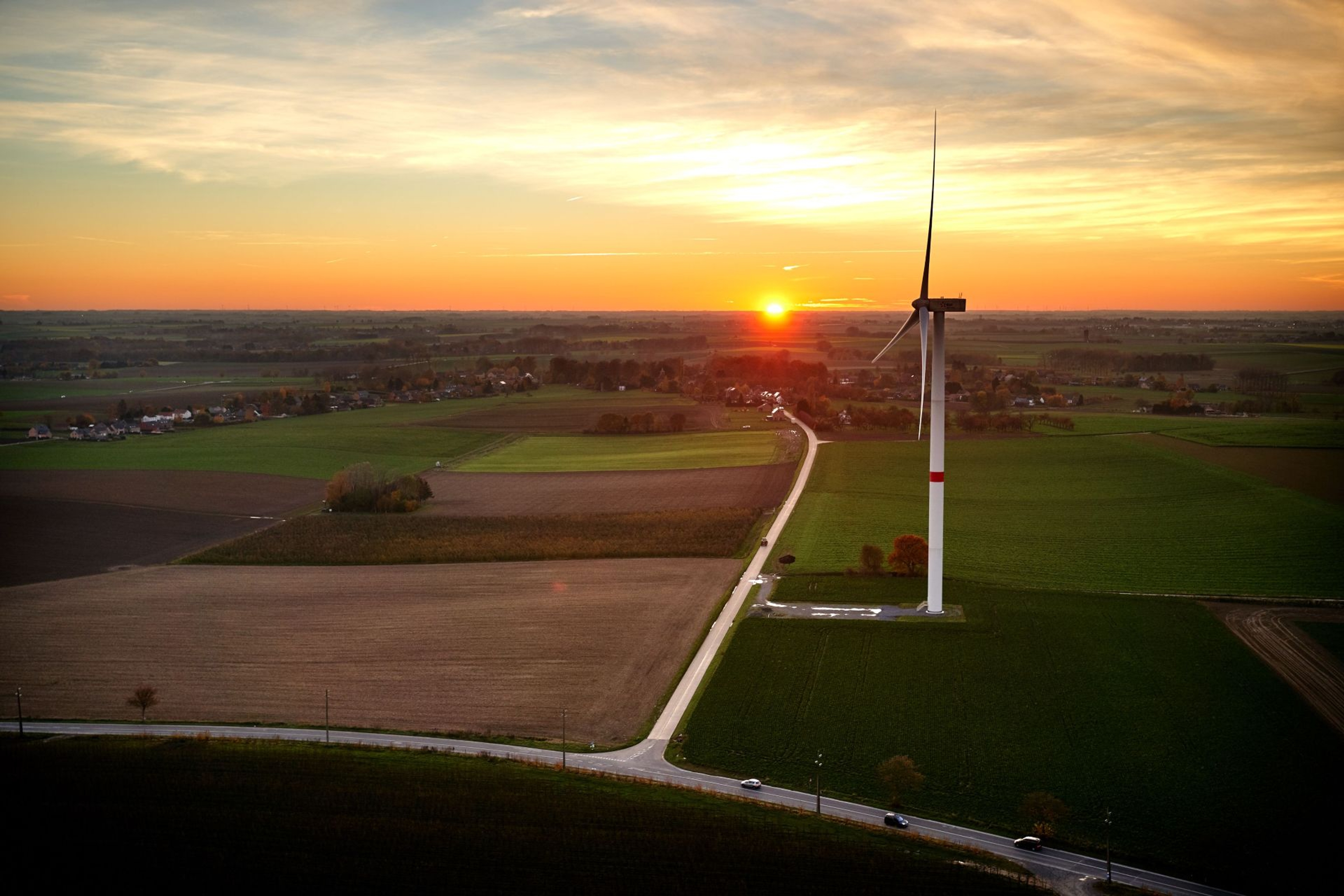 Éolienne au coucher du soleil en milieu rural.