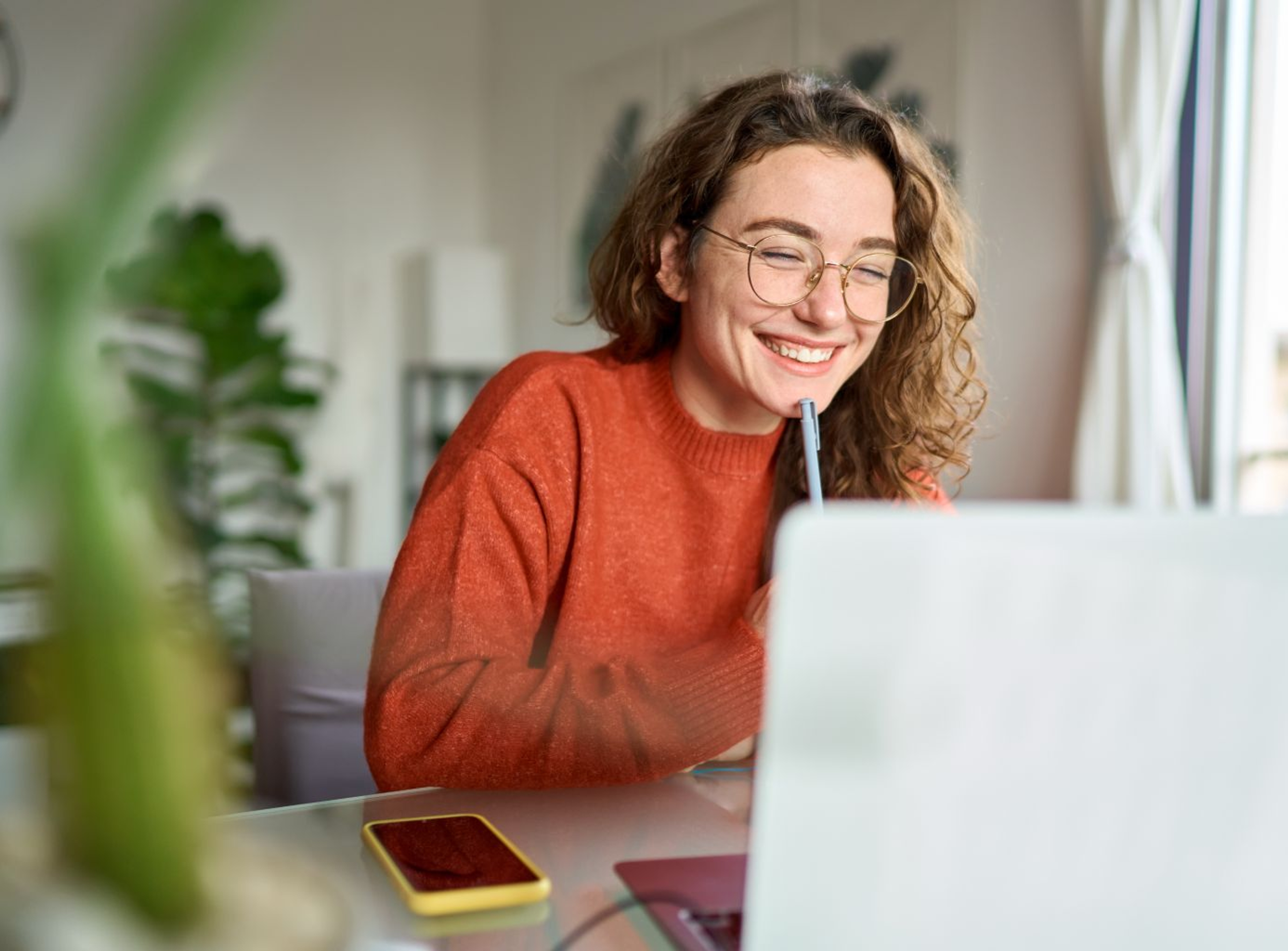 Jongedame lachend achter haar computer.