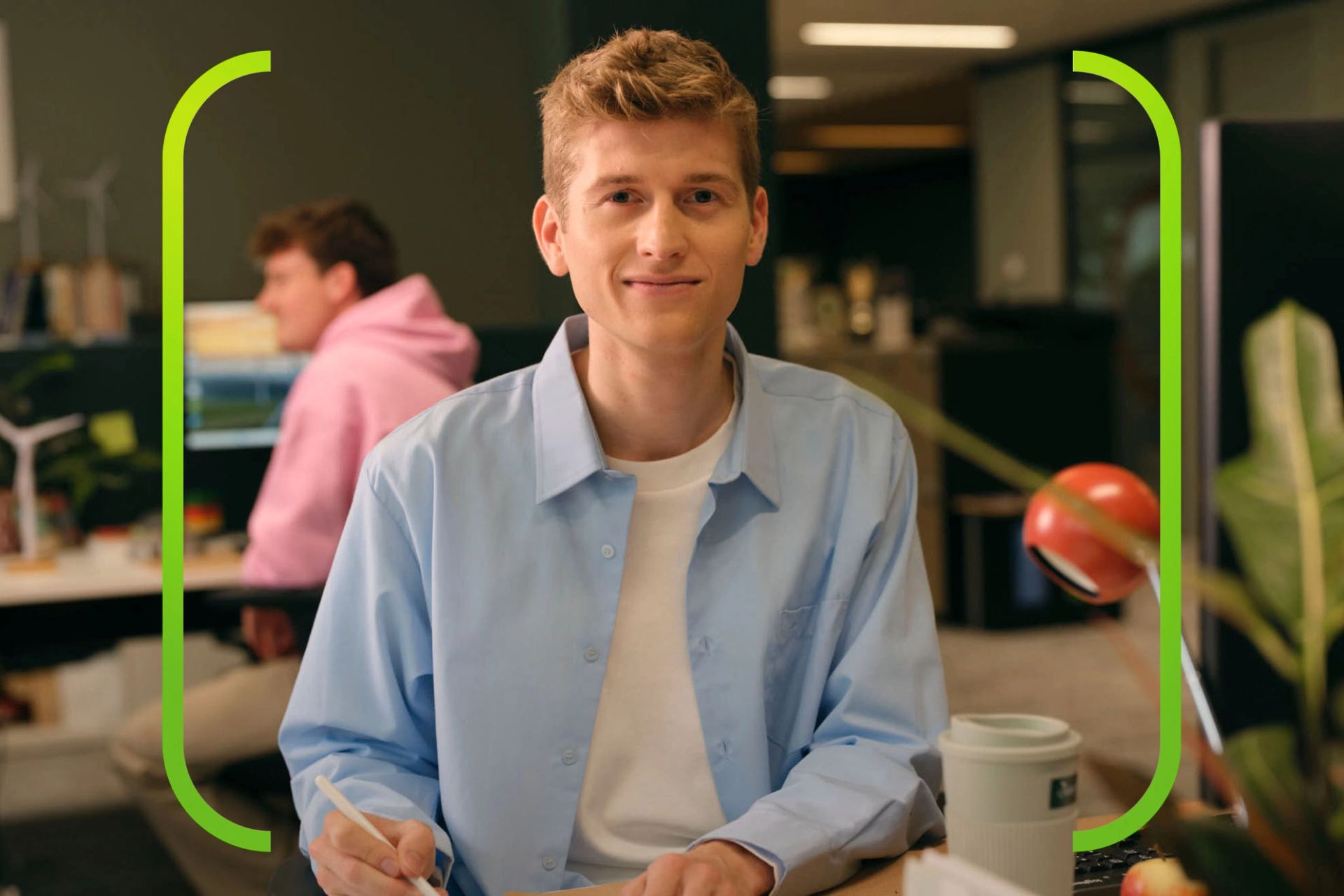 Portret van Young Graduate Toon aan zijn bureau op kantoor.