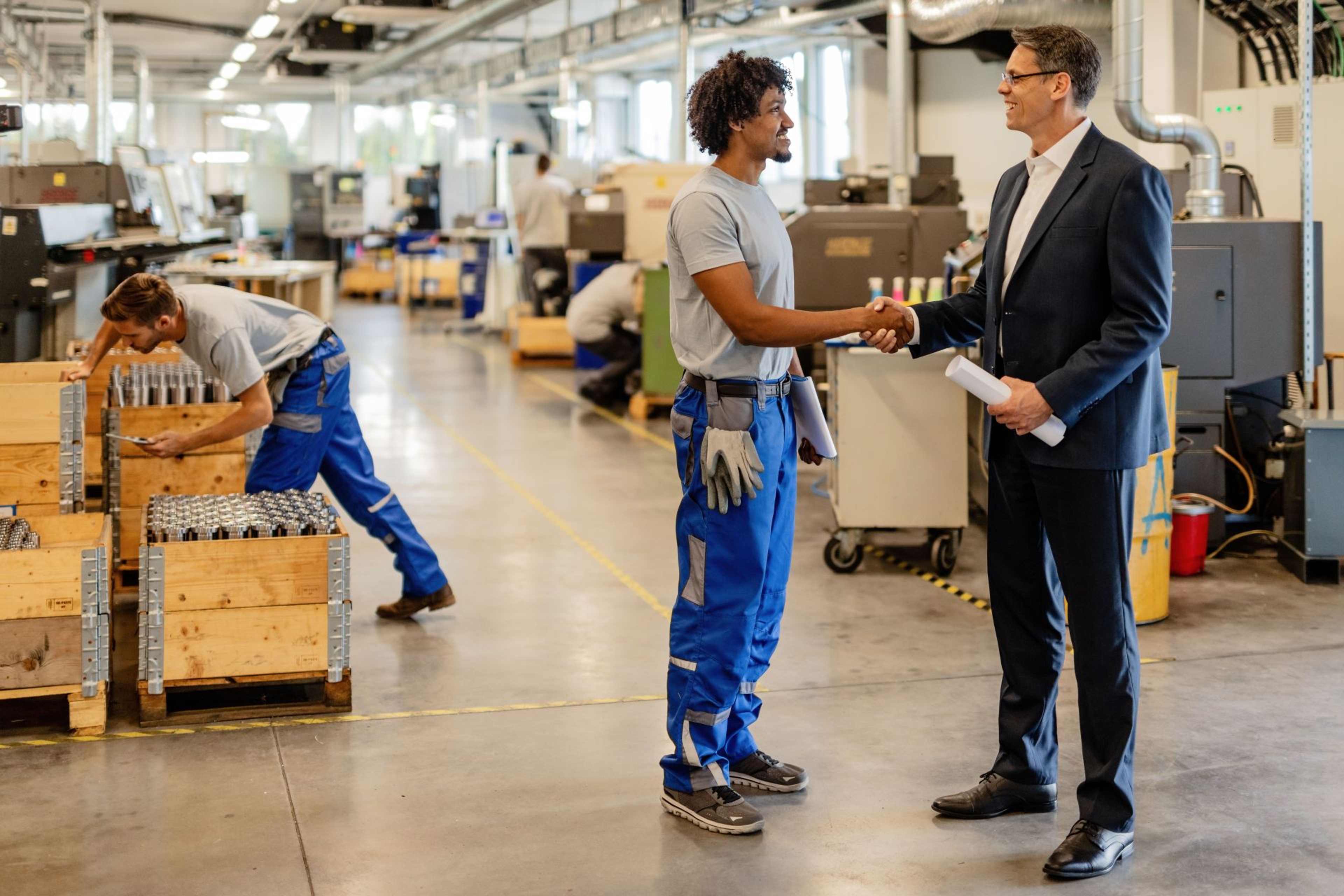 Werkplaats waar 2 mannen elkaar de hand schudden