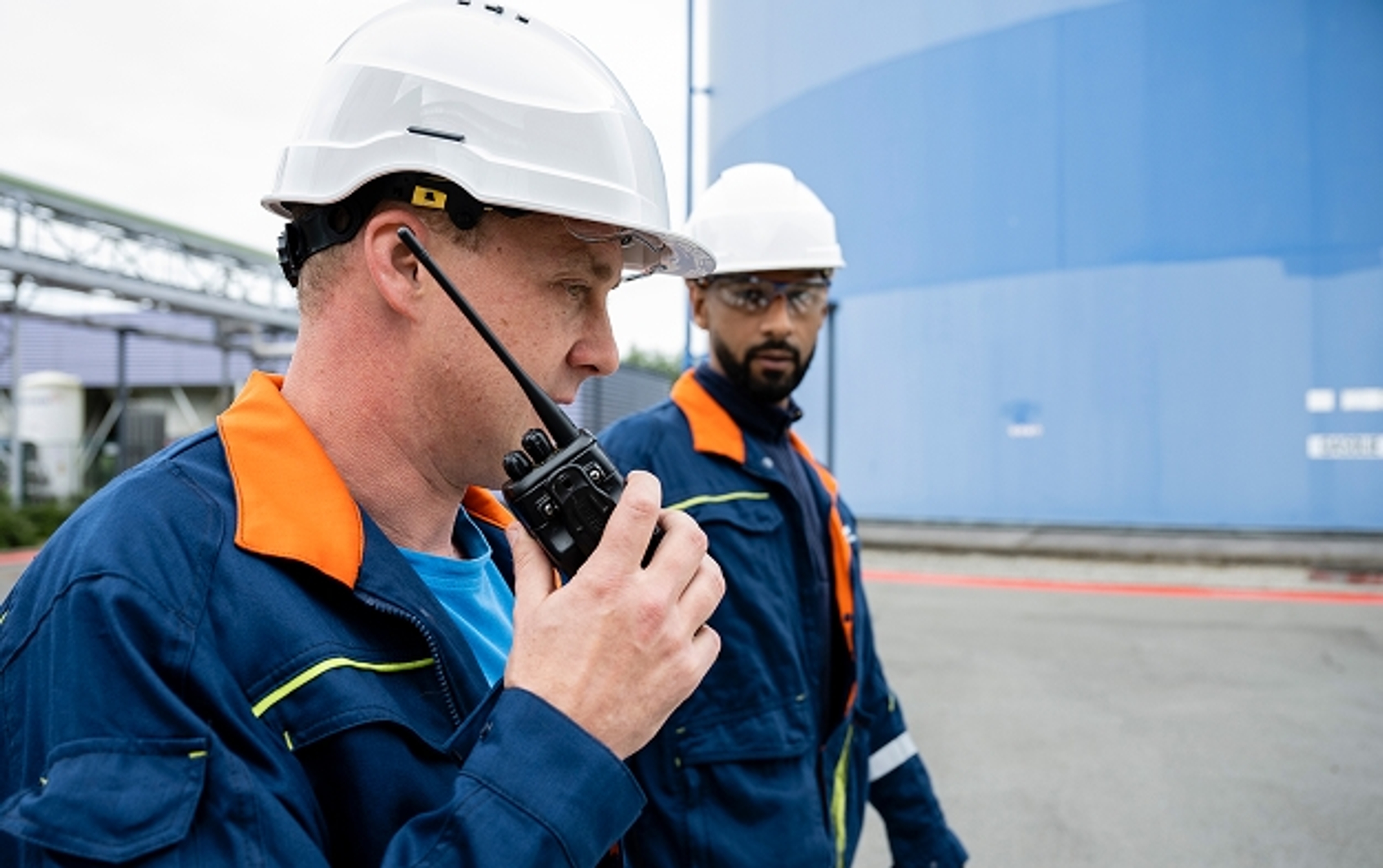 2 techniciens à l'intérieur d'un site devant des écrans de contrôle