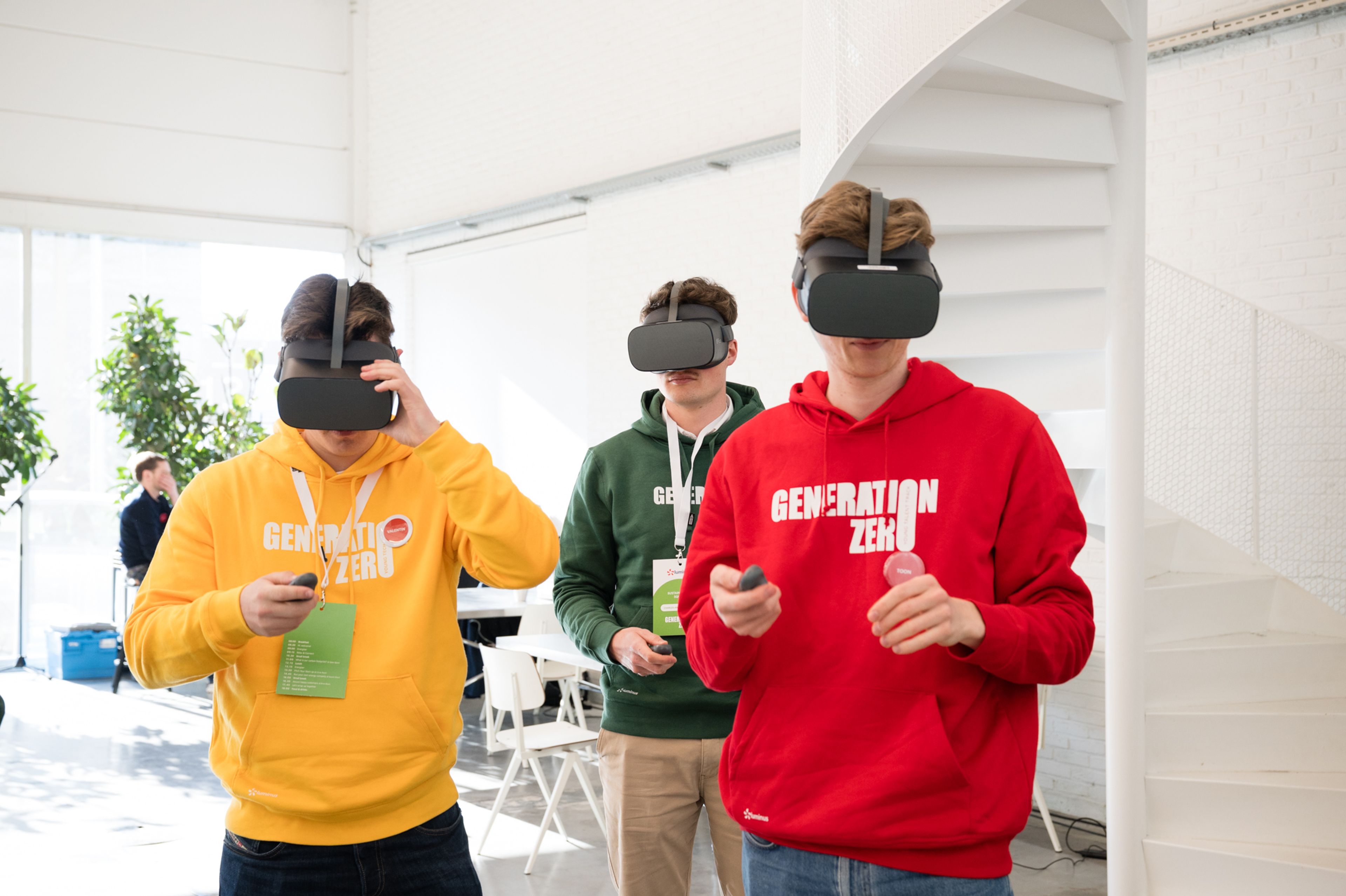 Zero Camp van Luminus, 3 jongens met VR-bril in witte ruimte. Ze dragen hoodies van Generation Zero: een geel, rode en groene.
