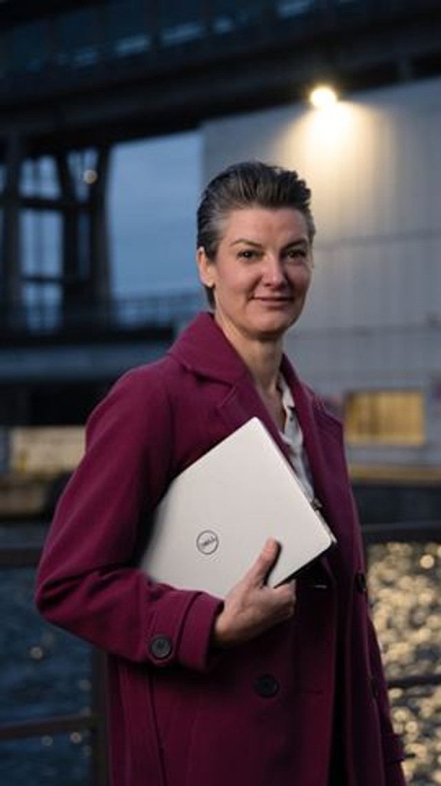 Suzy holding her laptop outside the waterpower installation.