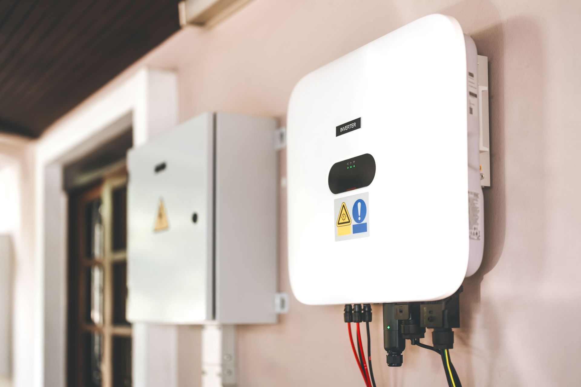 Onduleur solaire fixé au mur à côté d’un boîtier électrique