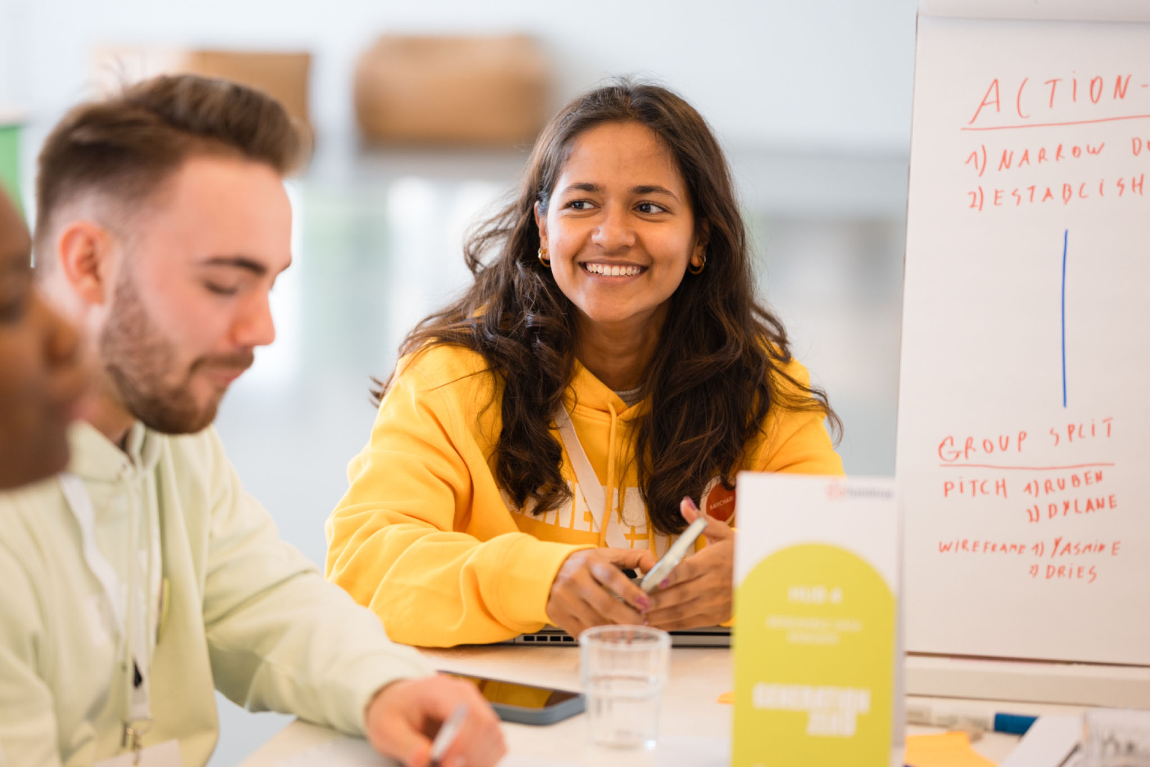 Sanchari souriant et scrollant sur son téléphone