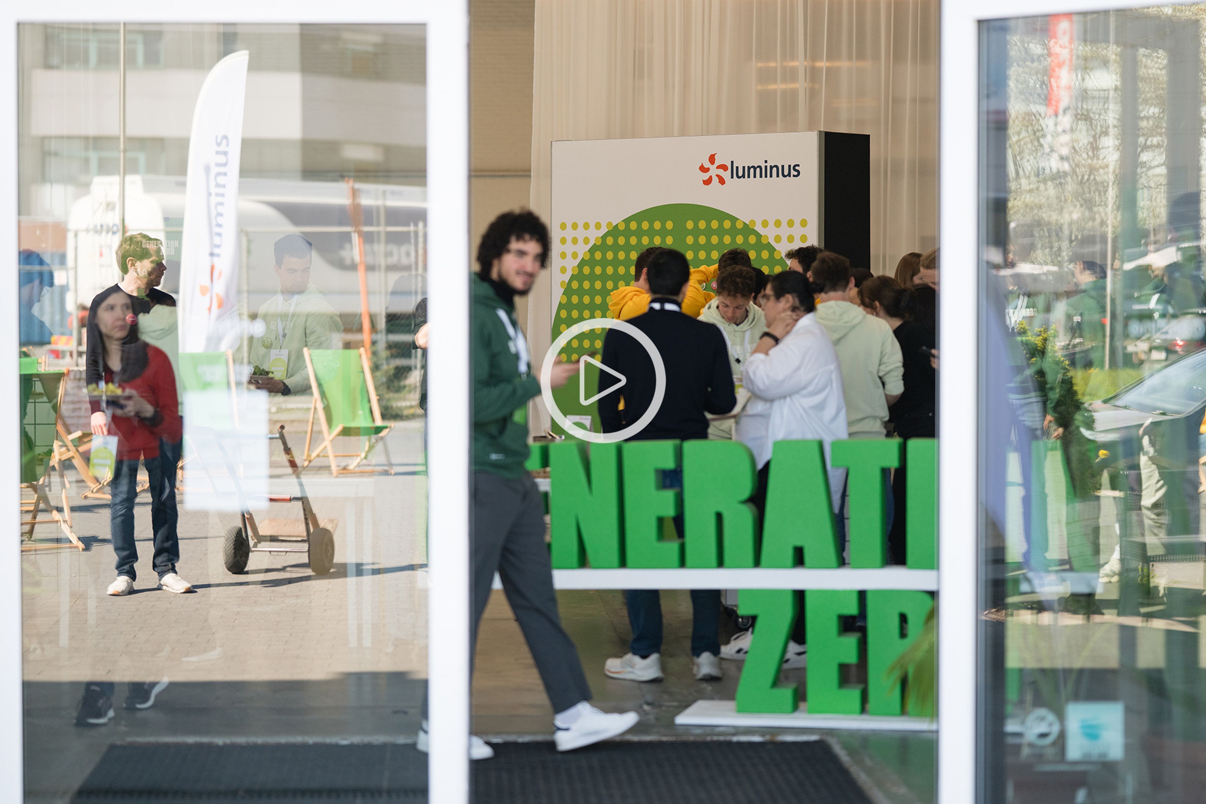 Zero camp: Openschuivende glazen deur, binnen de groene letters Generation Zero en groepje jongelui.