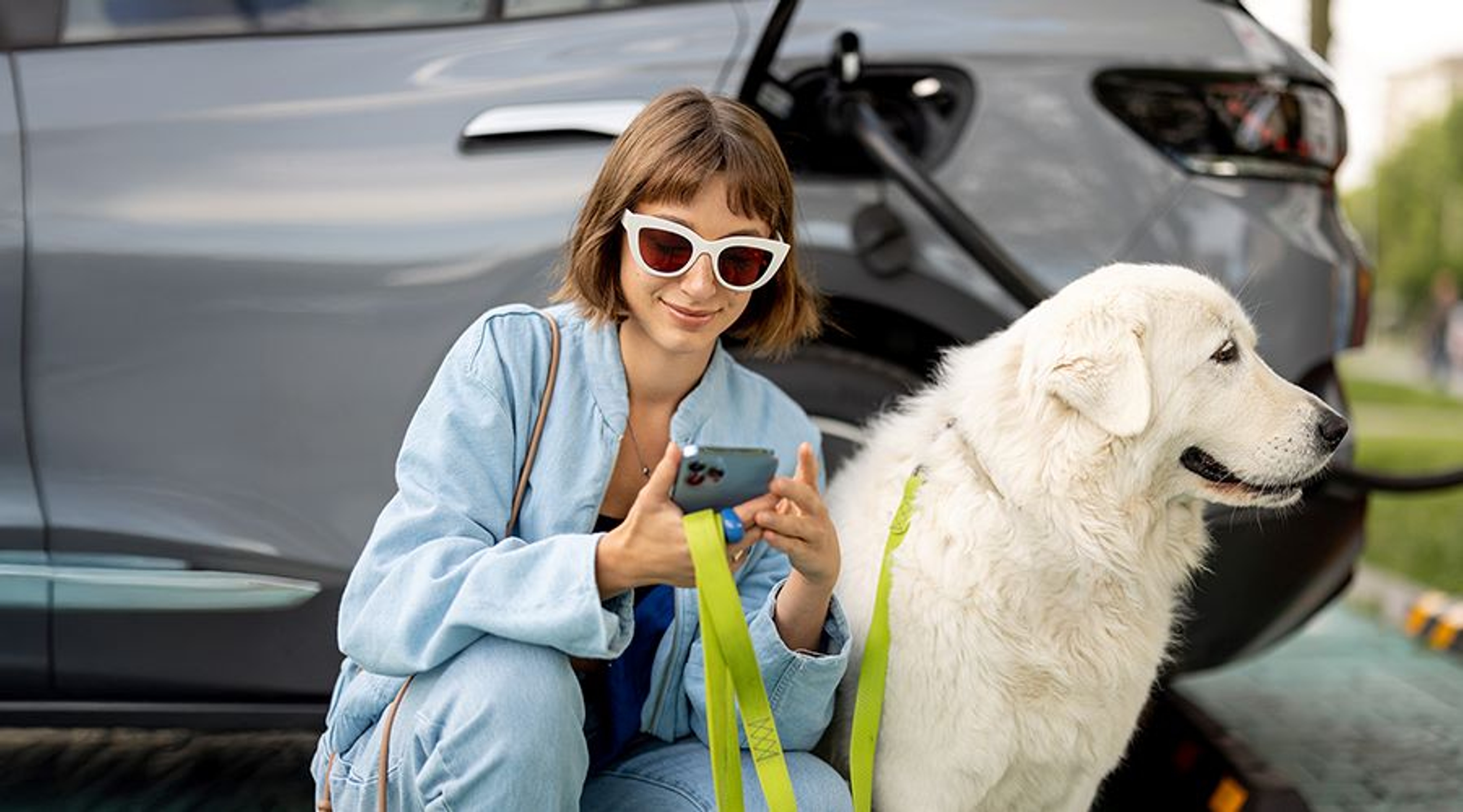 femme prête à promener son chien pendant que sa voiture électrique charge