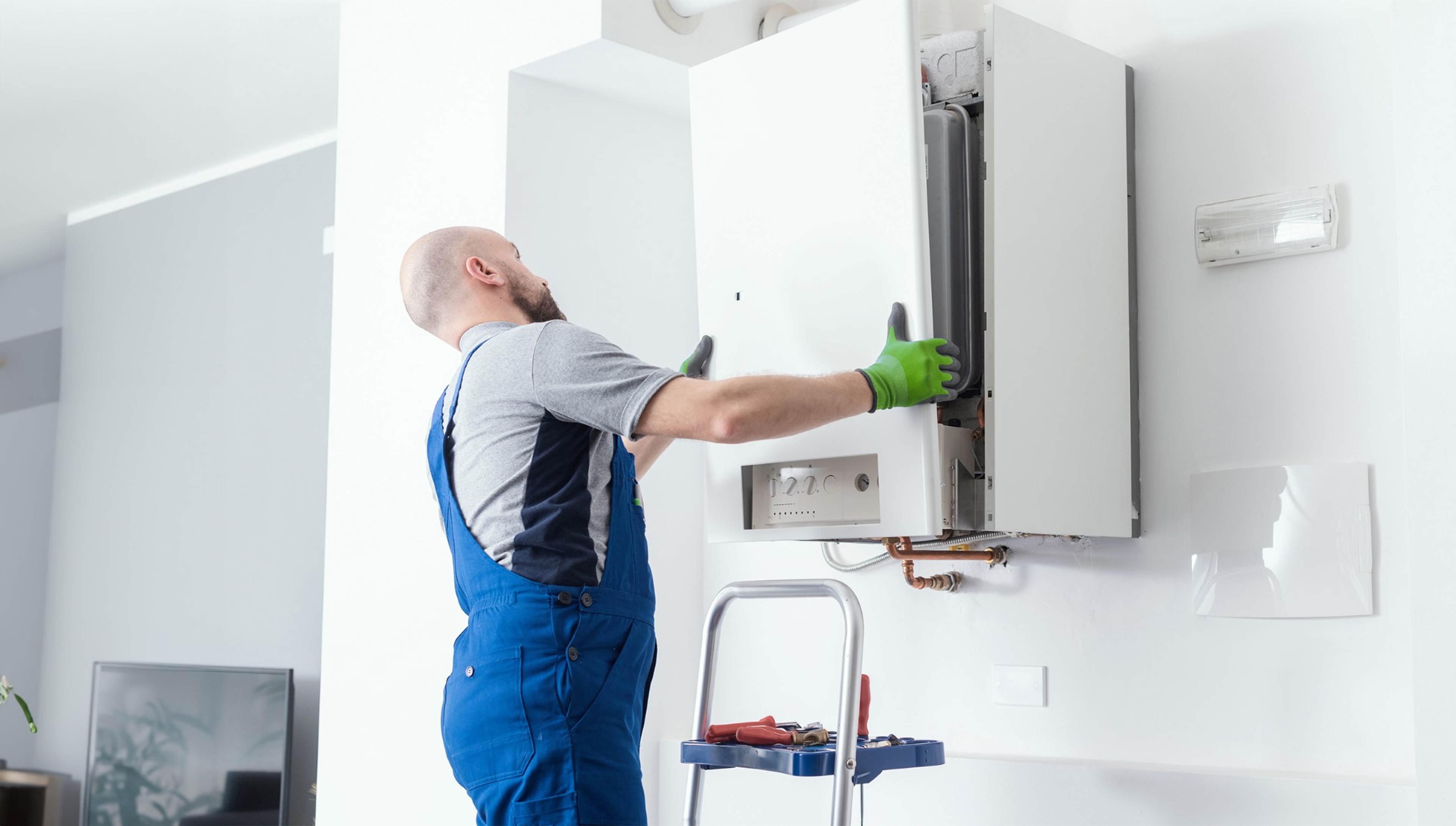 Erkende technieker neemt voorpaneel verwarmingsketel weg voor een interventie met Ketel Garantie.
