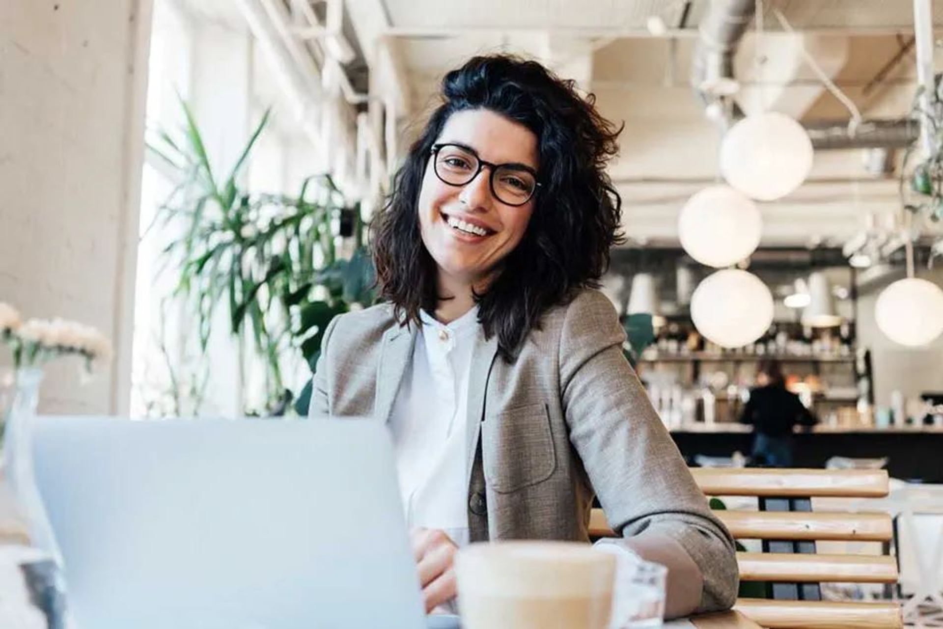 Jeune femme souriante devant son ordinateur