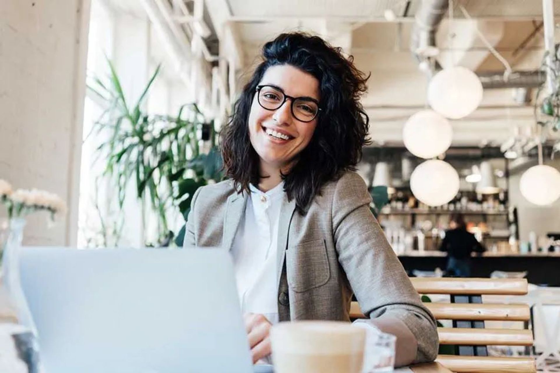 Jeune femme souriante devant son ordinateur