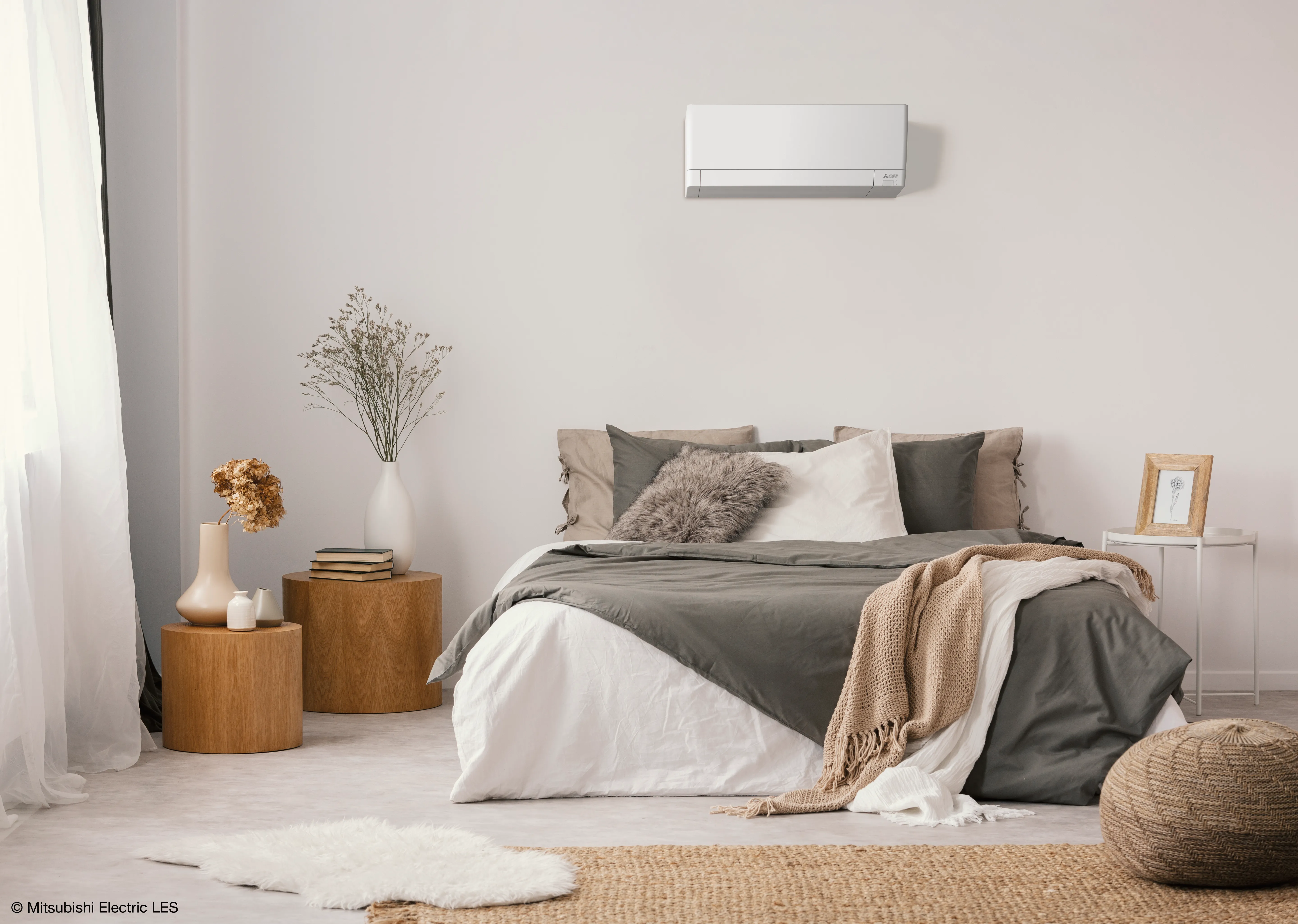 Dubbel bed in slaapkamer met daarboven een indoor airco module.