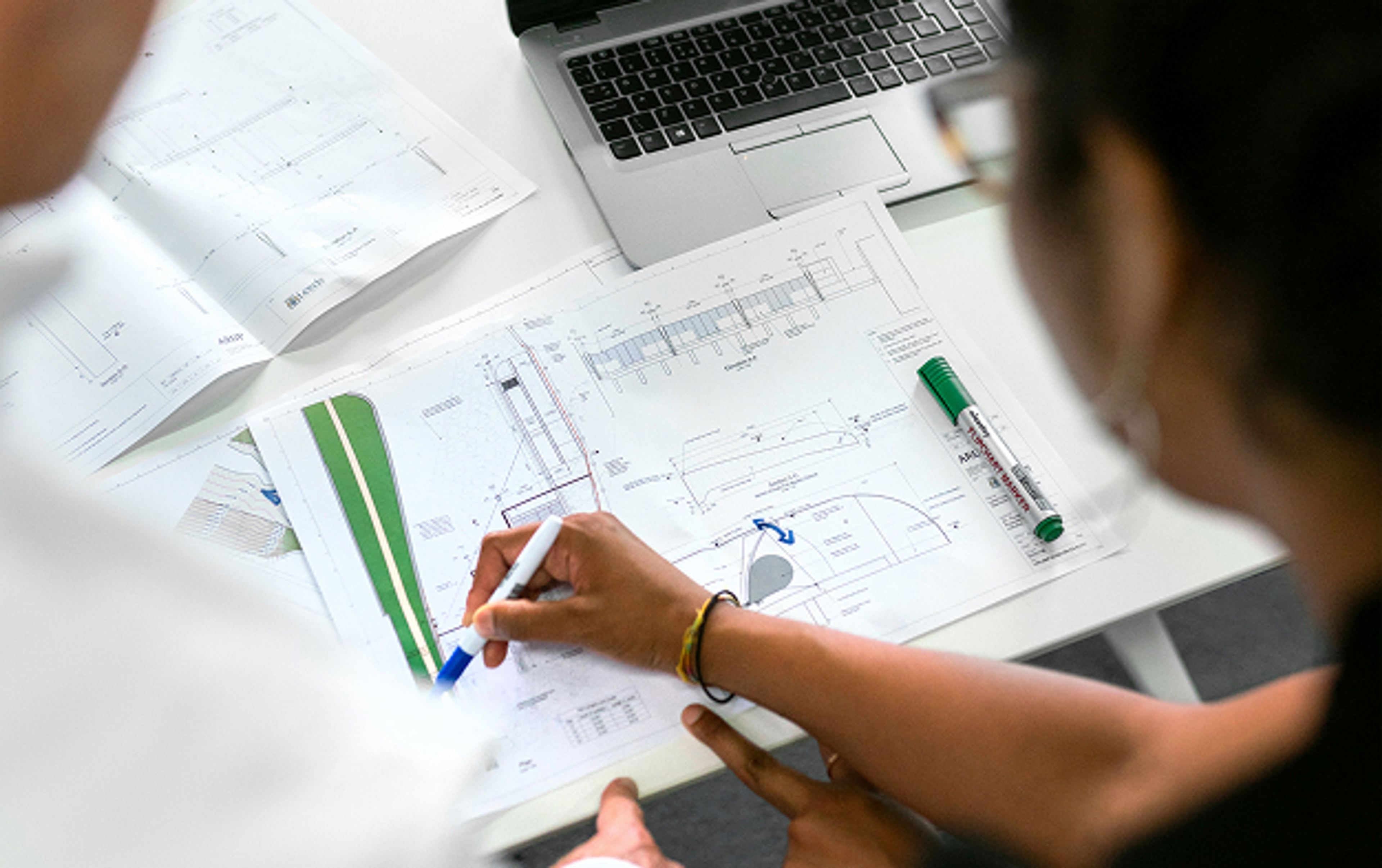 Femme faisant des annotations sur des plans papier