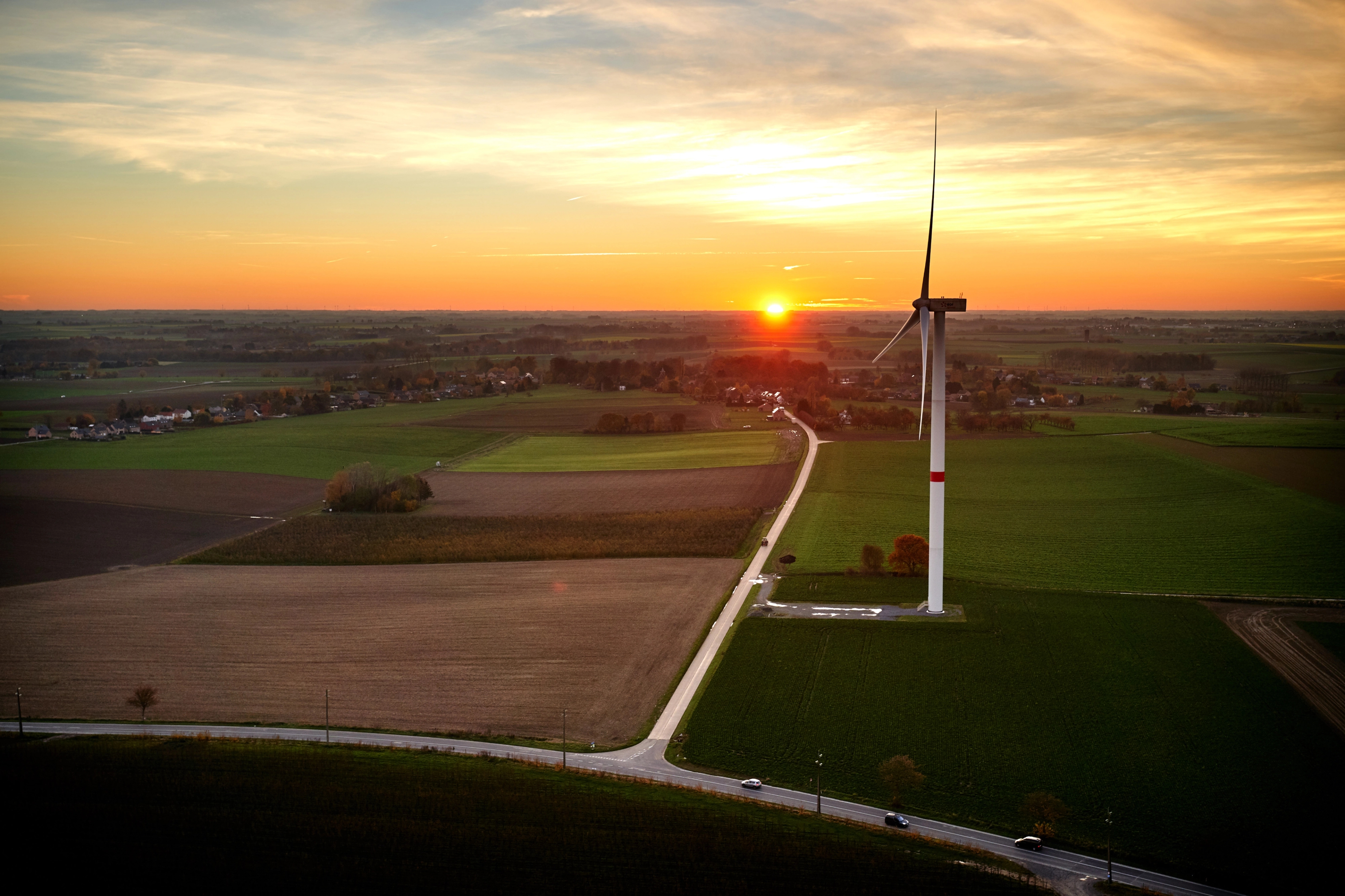 Windturbine bij landelijke zonsondergang.