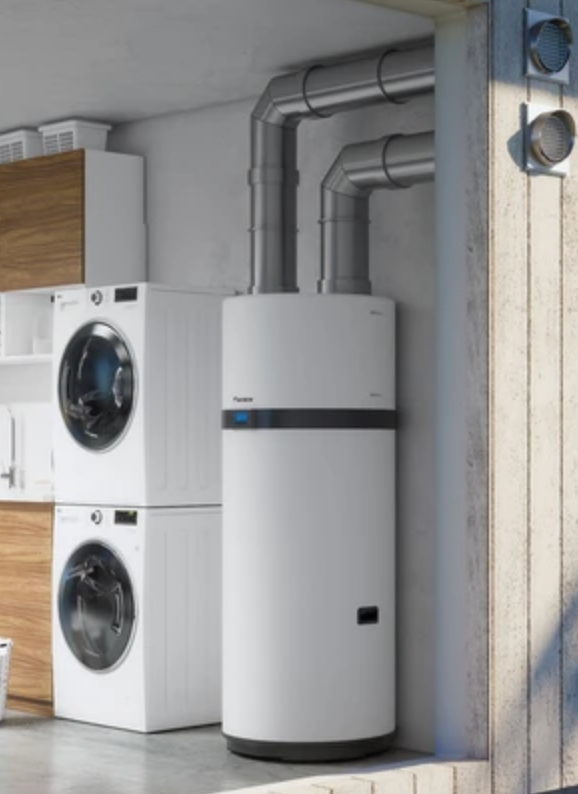 Chauffe-eau thermodynamique blanc dans un garage, à côté de la machine à laver et du sèche-linge