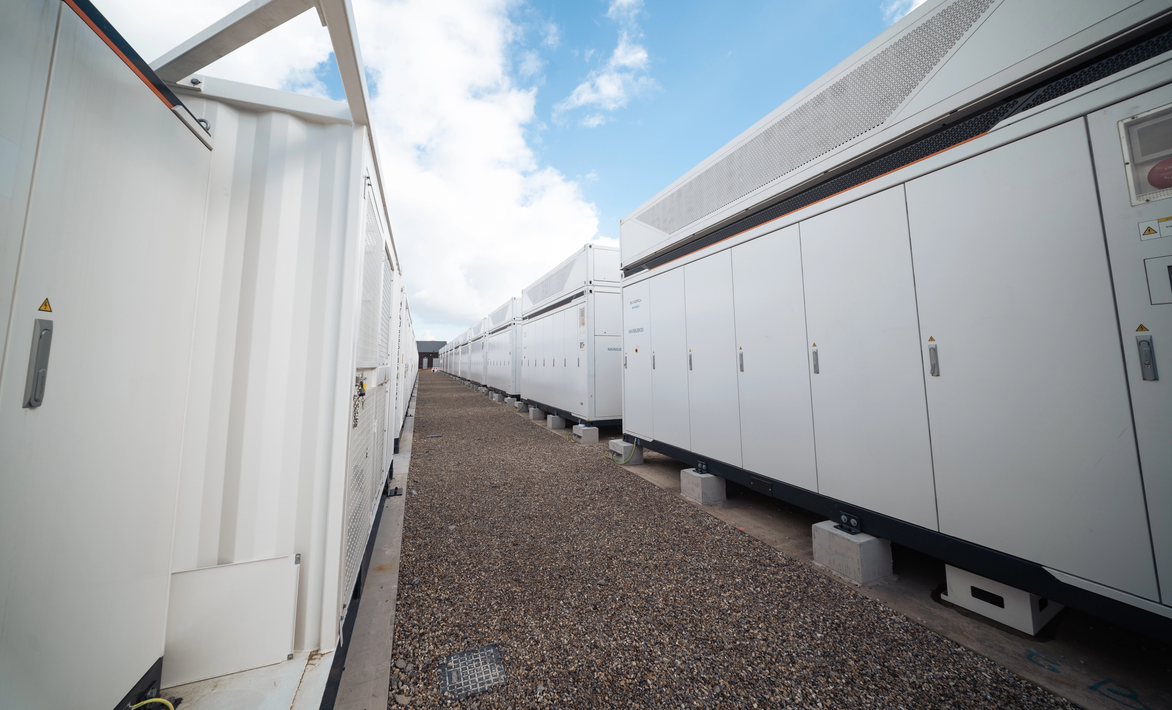 Batterijpark Navagne: grindpad tussen 2 rijen witte batterijcontainers.