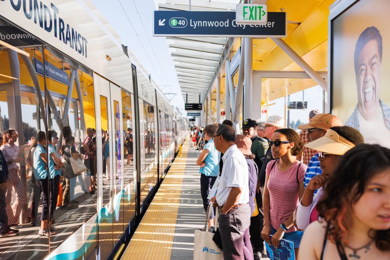 Crowded Sound Transit Link Light Rail platform at Lynnwood City Center station on opening day with a train arriving