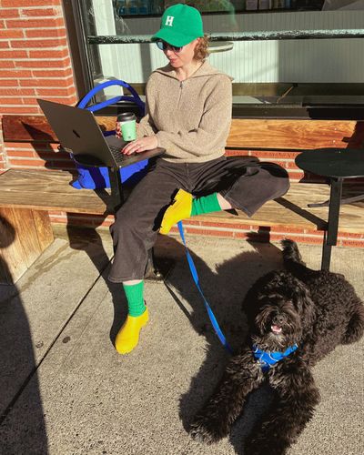 A women working outside next to her dog