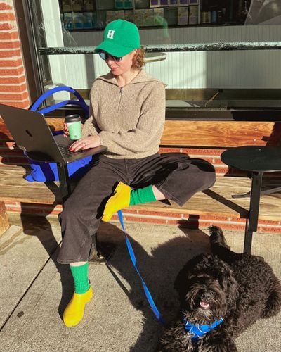 A women working outside next to her dog