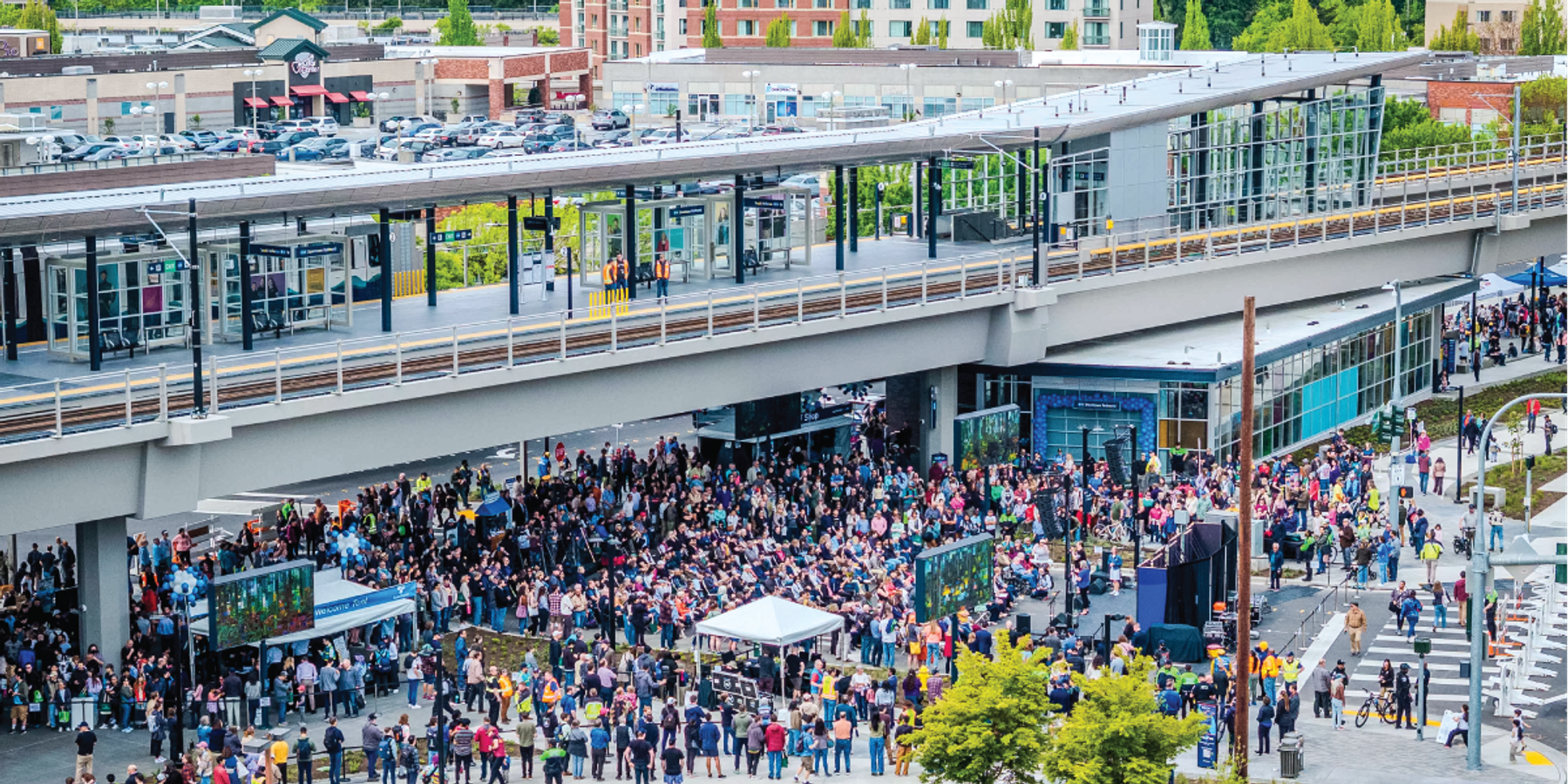 Aerial view of a large crowd gathered below the elevated Sound Transit Link Light Rail platform at the opening ceremony