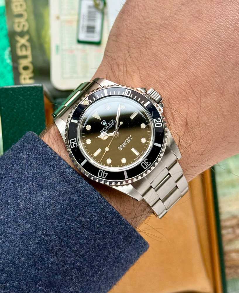 Wrist shot image for Rolex Submariner 14060 Black 1997 with original box and papers