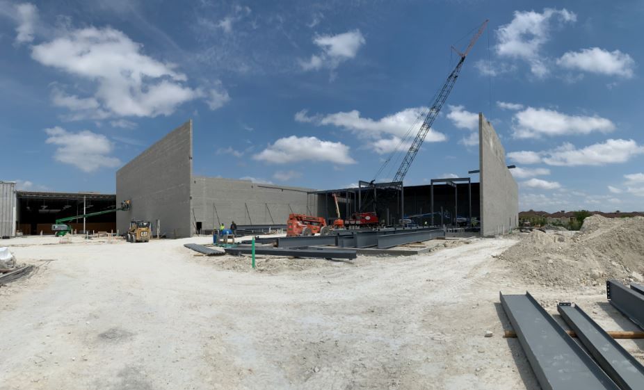 Overview of the project site, focusing on the perimeter CMU walls of the new AMC theater.