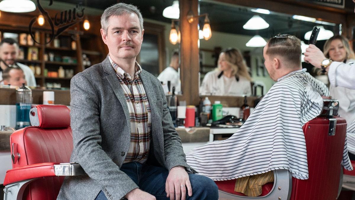 Peter sat in a barber chair facing camera