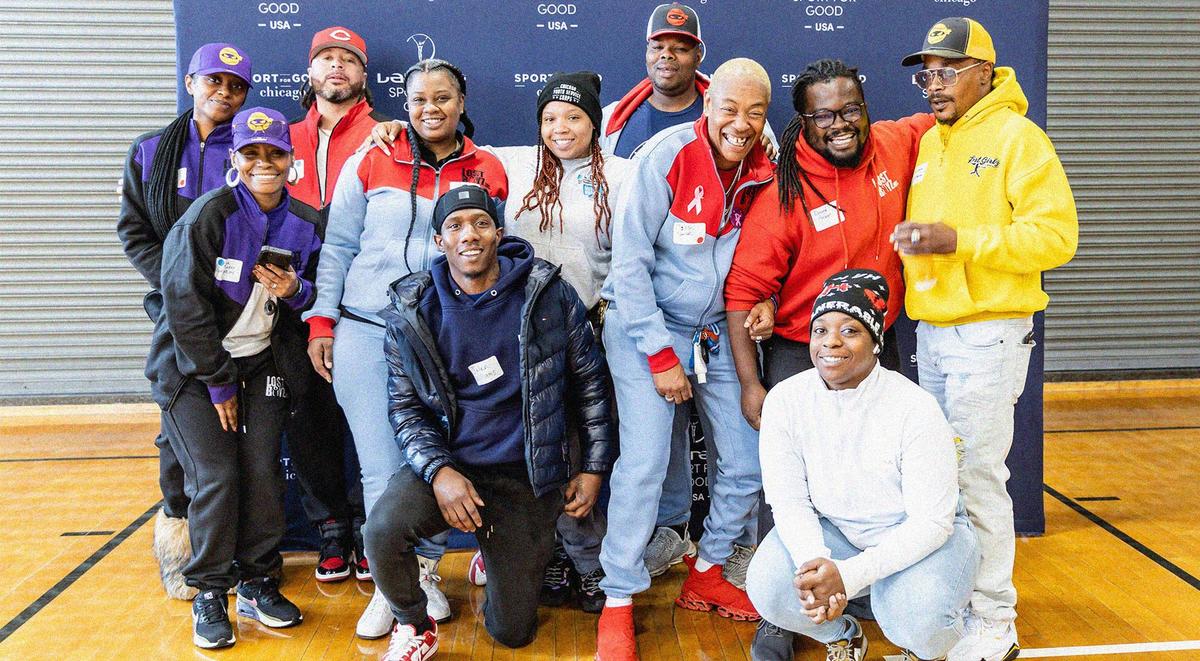 Group of people posing in front of a promotional banner for Laureus USA and Sport for Good in Chicago 