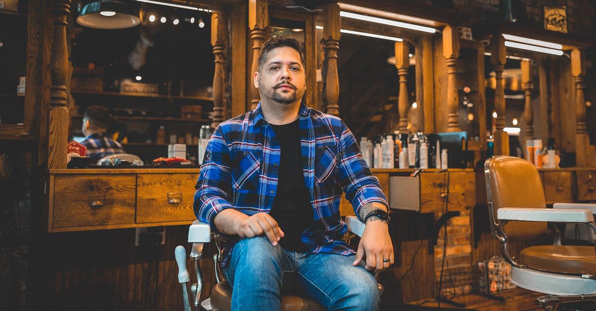 Moustachioed man poses for his portrait in a barbershop
