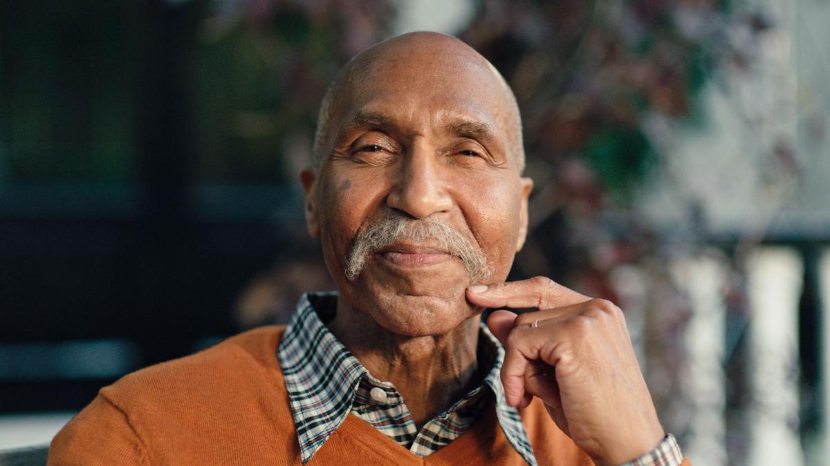 A suave gentleman stares into the camera, as he shows off his glorious moustache