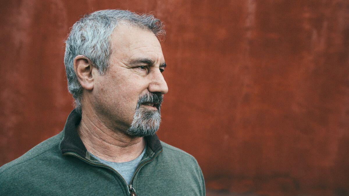 Close up of older man in green jumper looking to one side