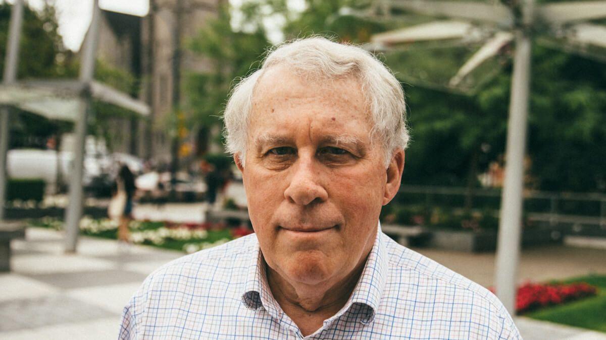 Older man standing outdoors in a town square