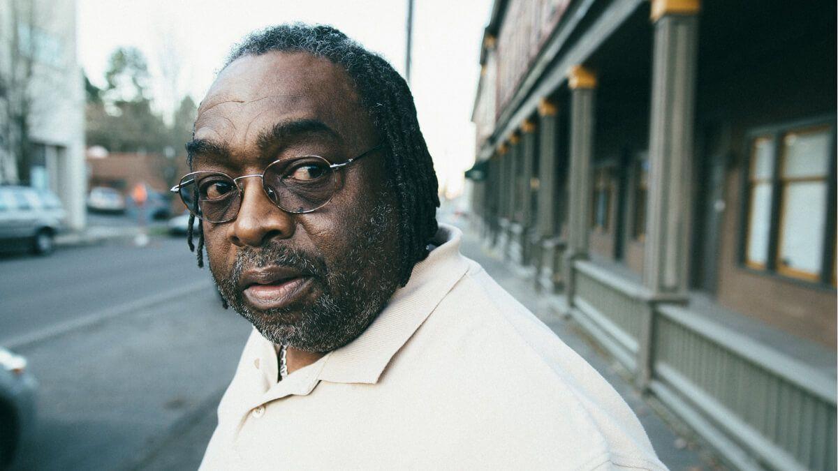 Older Black man with spectacles standing in the street